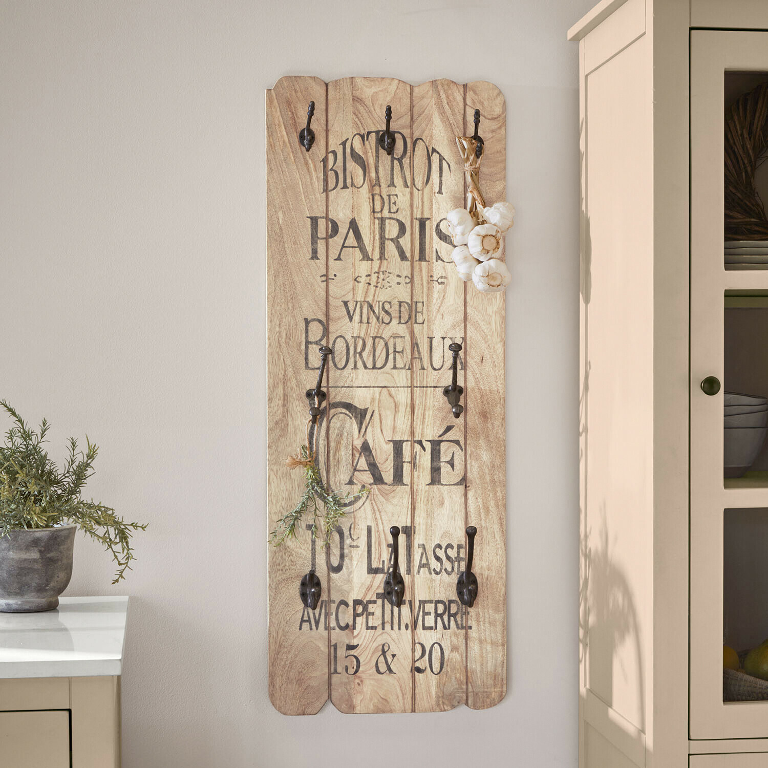 Wandgarderobe aus hellem Holz mit schwarzen Metallhaken und französischem Vintage-Schriftzug