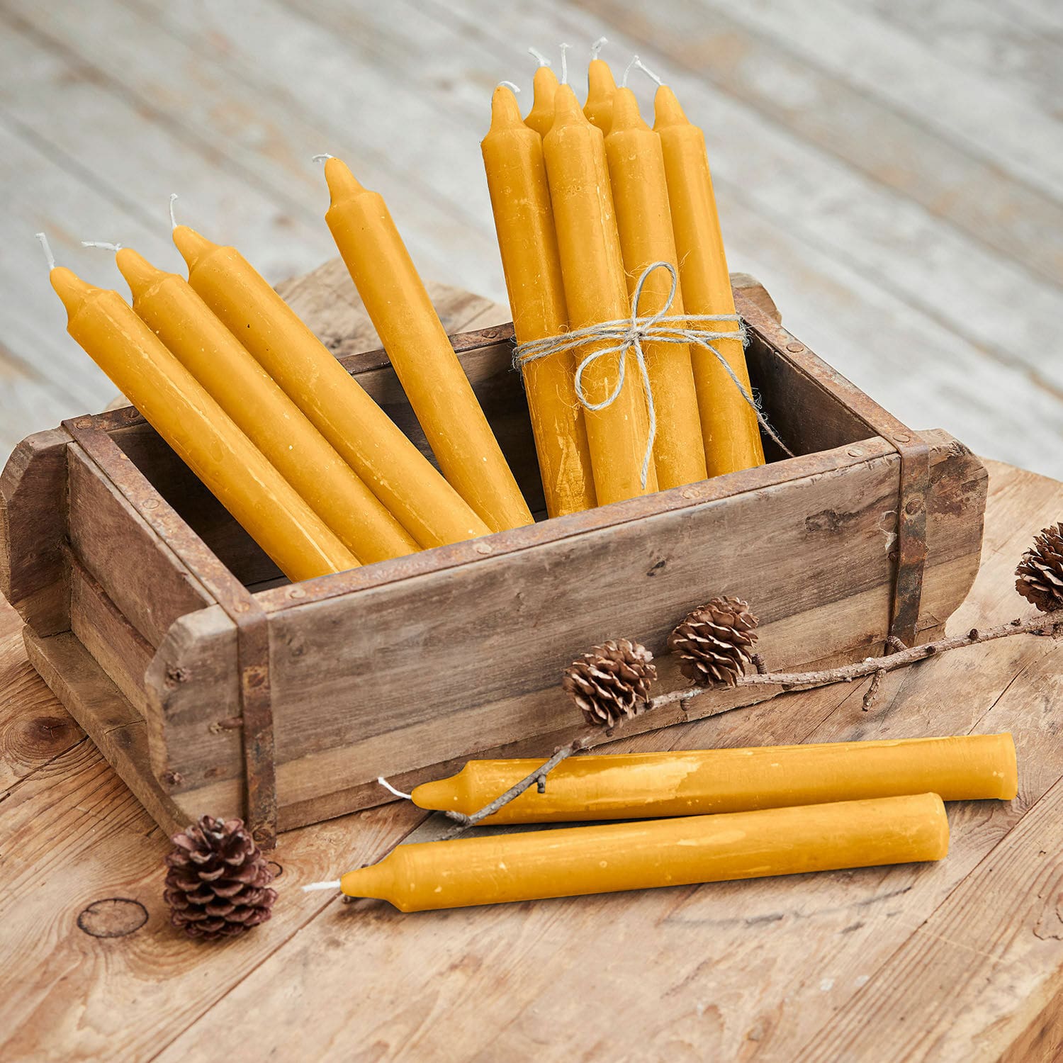 Kerze 12er Set Bauceau Set aus gelben Bienenwachskerzen in Holzkiste auf rustikalem Holztisch