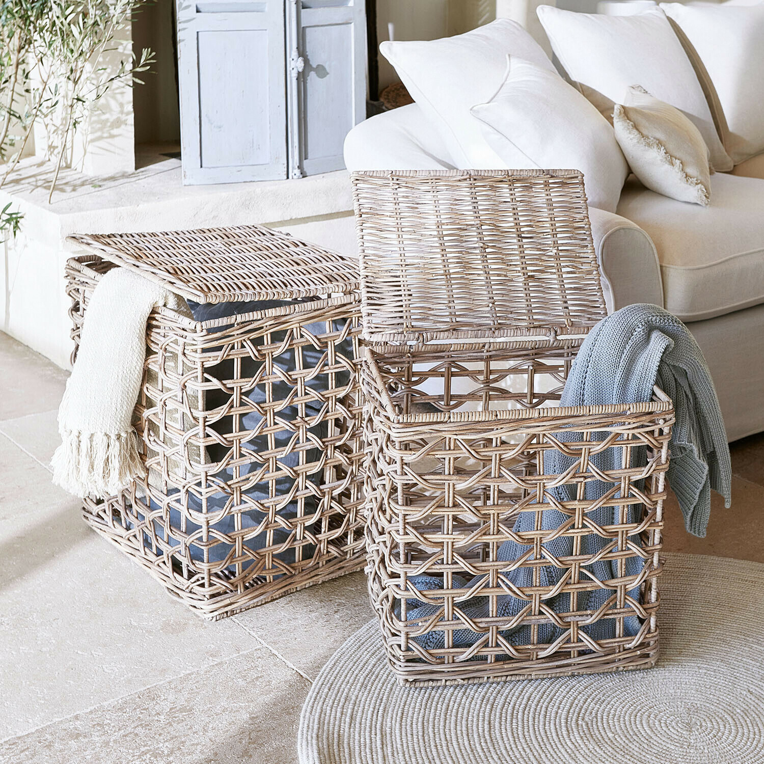 Zwei natürliche Rattankörbe mit Decken, praktische Aufbewahrungslösung im hellen Wohnzimmer