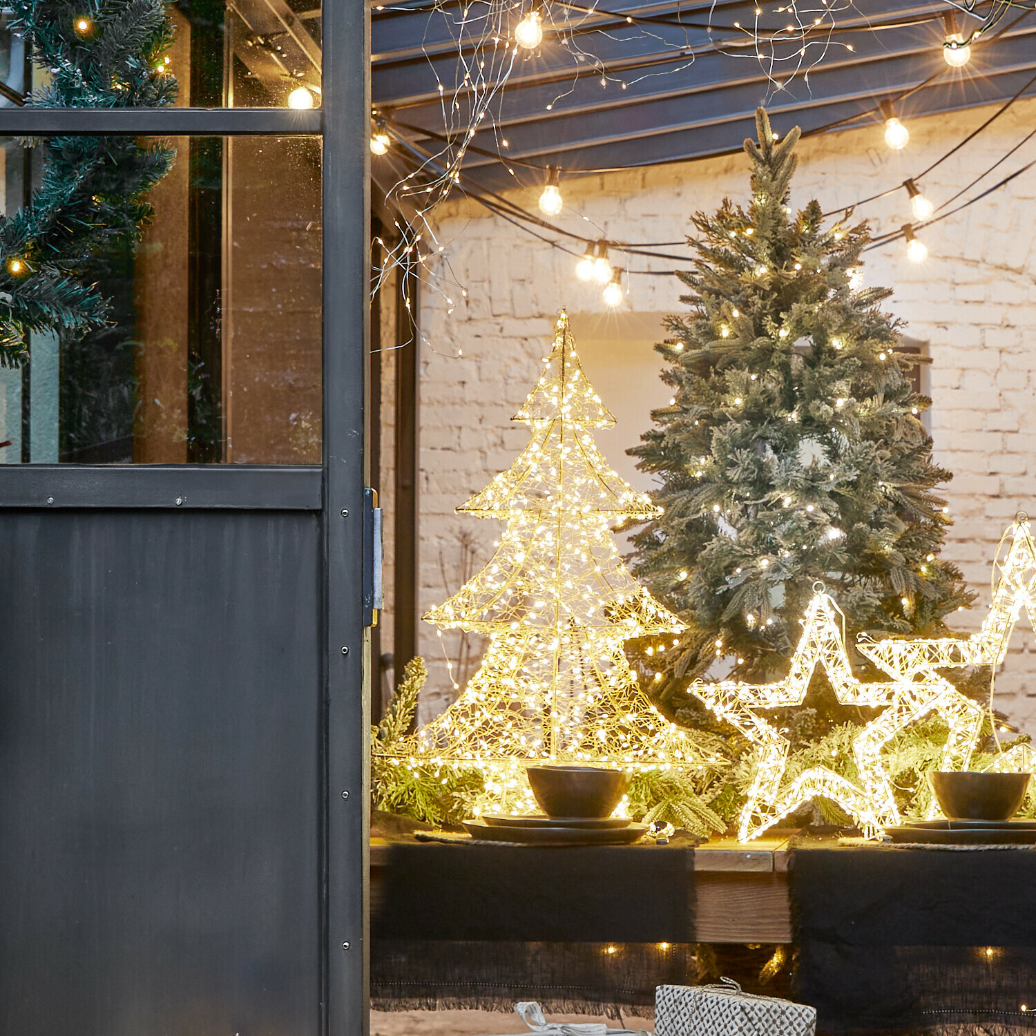 LED-Baum Vivetelle LED-Weihnachtsdekorationen in Tannenbaum- und Sternform auf Holztisch mit grünen Zweigen