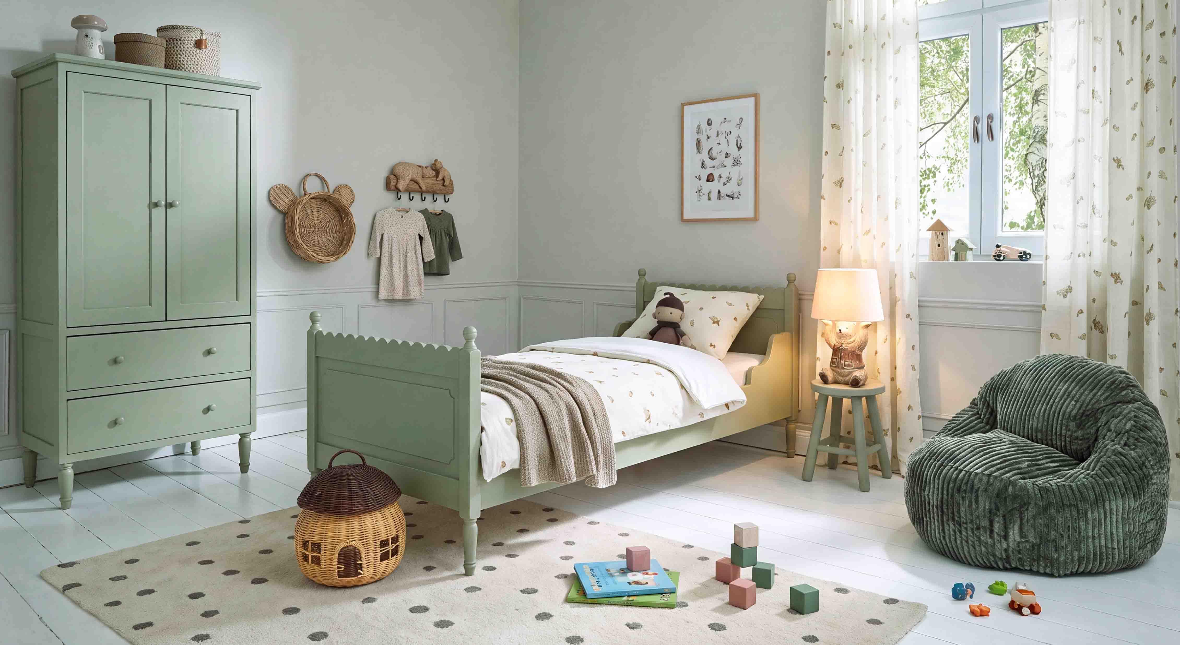 Pastellgrüner Holzschrank und Bett im Kinderzimmer mit weichem Sessel und Spielzeug