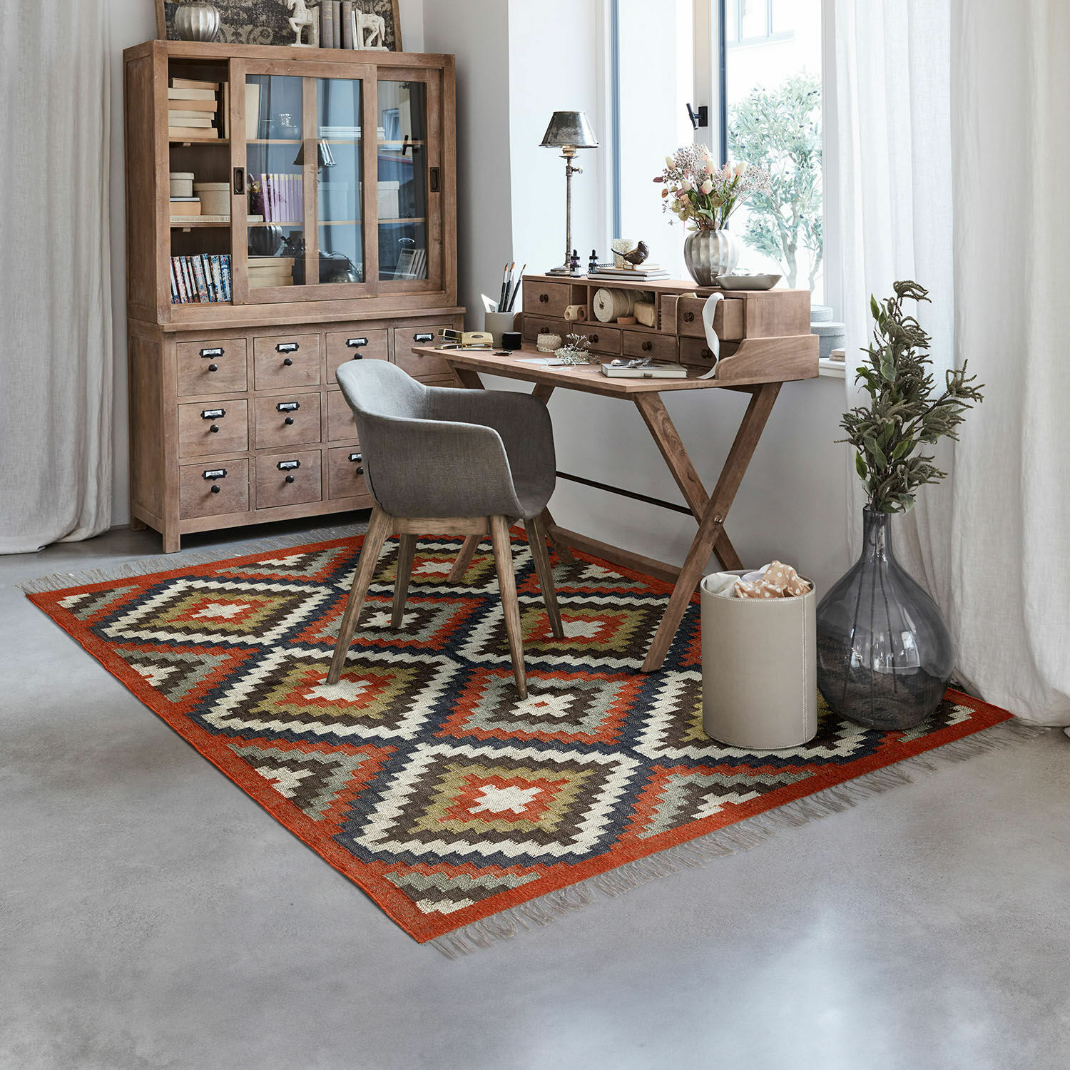 Teppich Dailies Geometrisch gemusterter Teppich in warmen Farben in einem modernen Arbeitszimmer mit Holzschreibtisch und grauem Stuhl