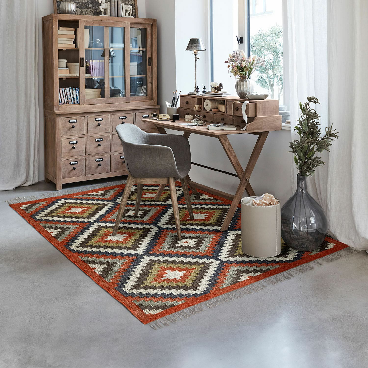 Teppich Dailies Geometrisch gemusterter Teppich in warmen Farben in einem modernen Arbeitszimmer mit Holzschreibtisch und grauem Stuhl