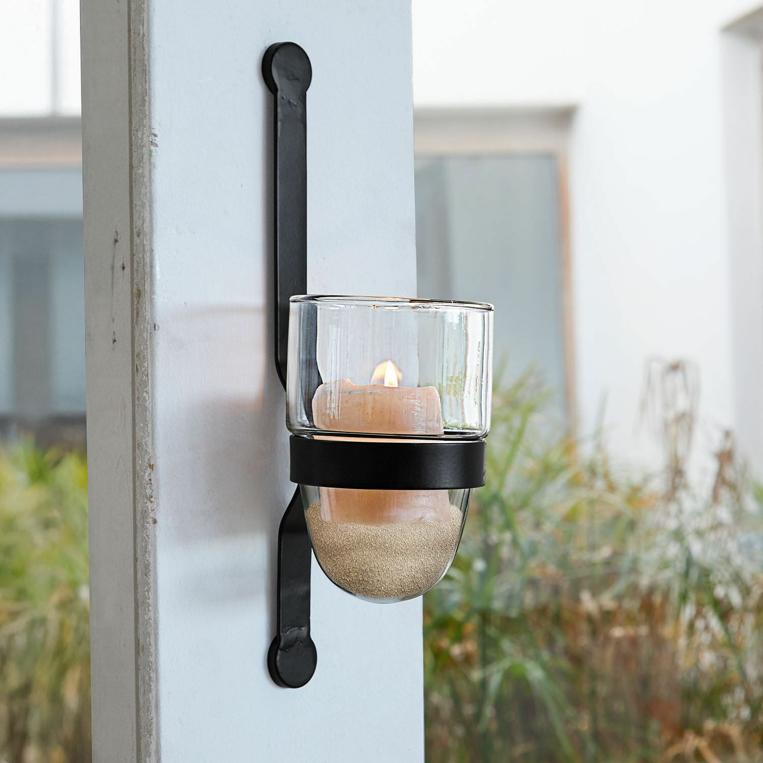 Wandkerzenhalter Astalis Schwarze Metall-Wandleuchte mit klarem Glas-Teelichthalter und brennender Dekokerze