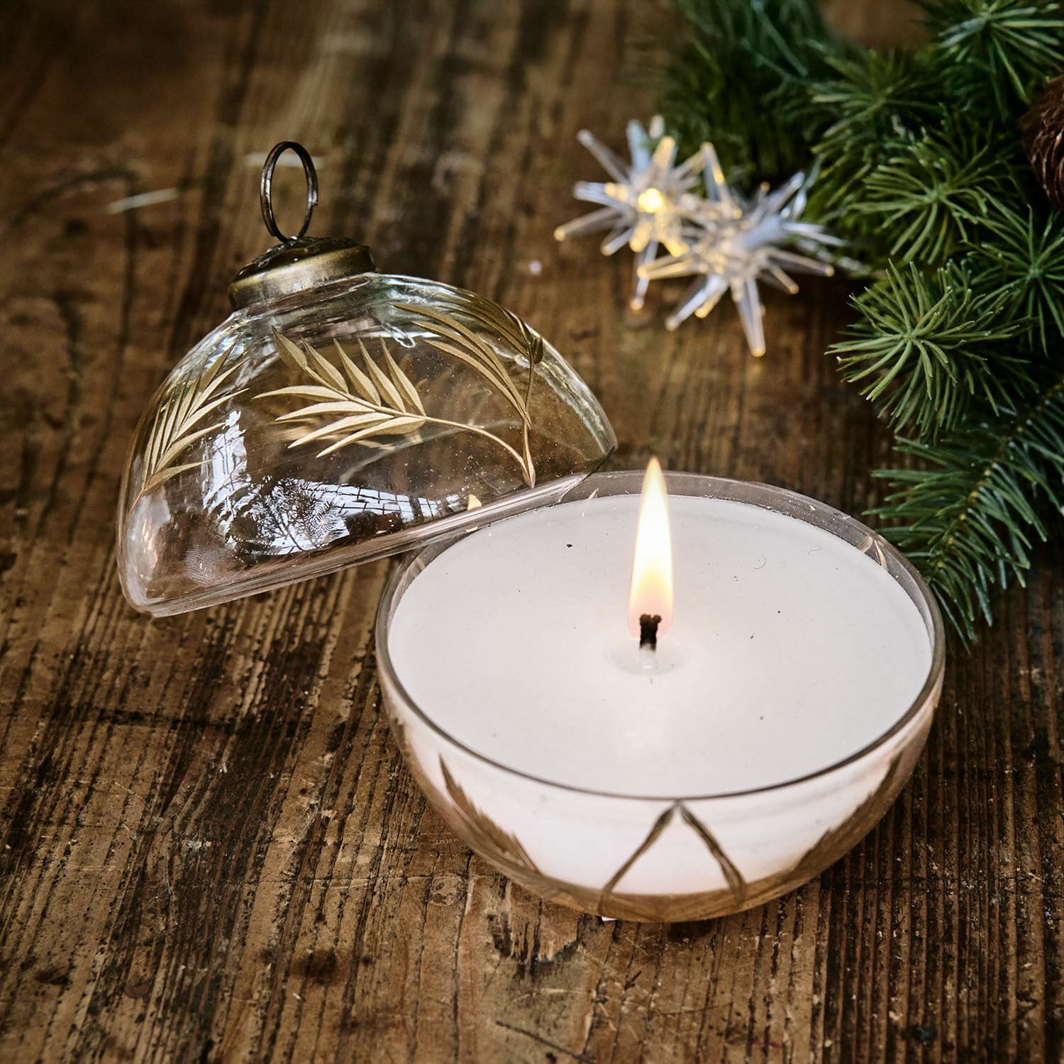Windlicht mit Kerze Belathor Duftkerze in klarem Glas mit goldenem Blattmuster auf rustikalem Holztisch dekorativ platziert