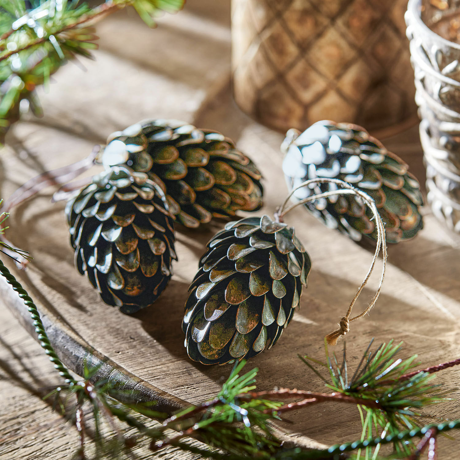 Anhänger 4er Set Lonrai Dunkle Metall-Tannenzapfen mit Aufhängung als Weihnachtsdekoration auf Holztablett