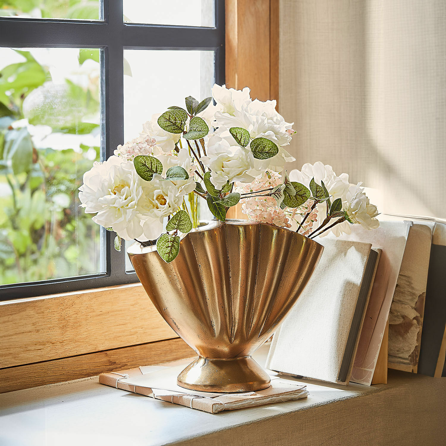 Vase Chavelot Goldene Metallvase mit weissen Blumen auf der Fensterbank, stilvolle Wohnraumdekoration