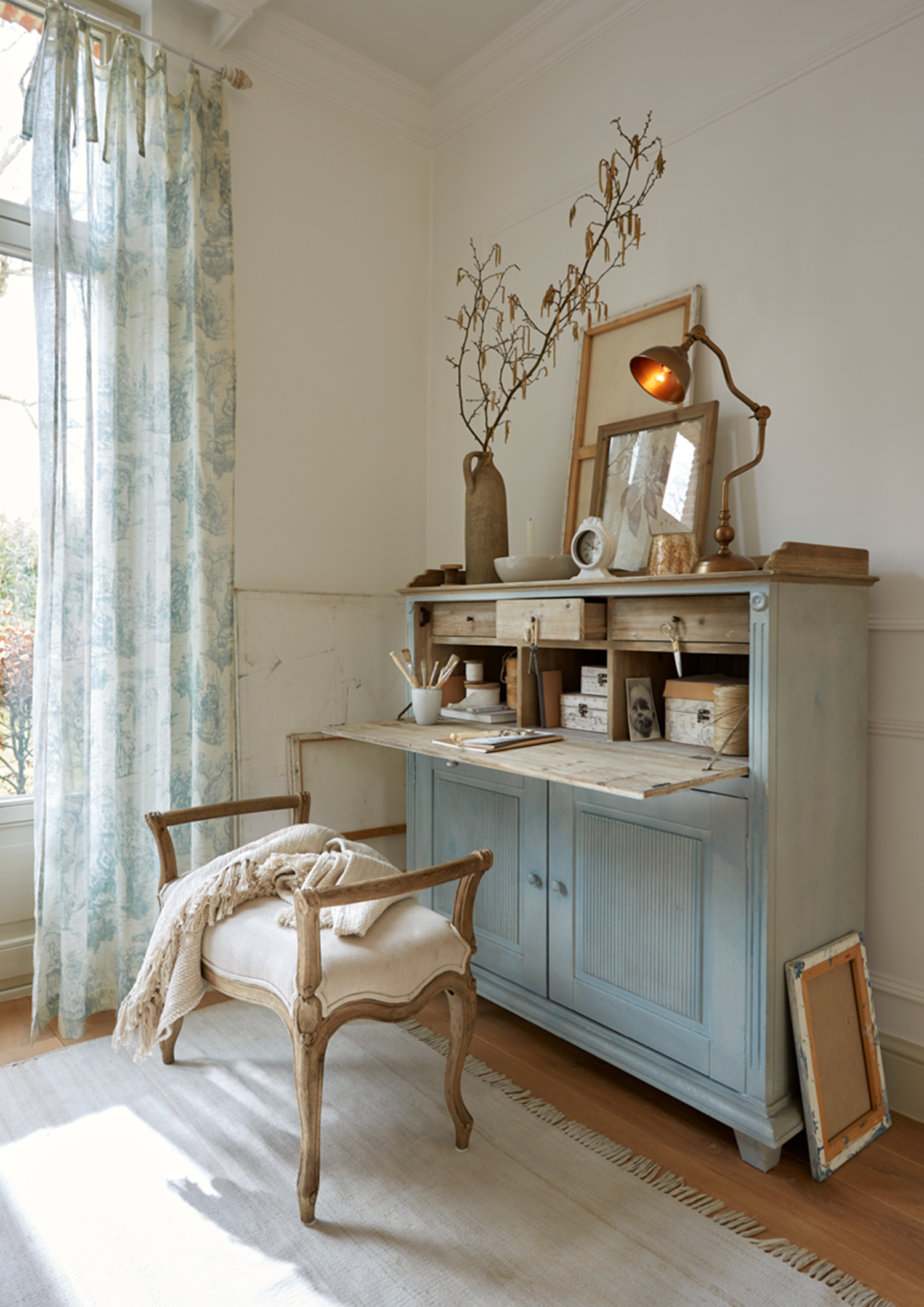 Blaues Holzsideboard mit klappbarer Arbeitsfläche und Dekorationen in hellem, gemütlichem Raum