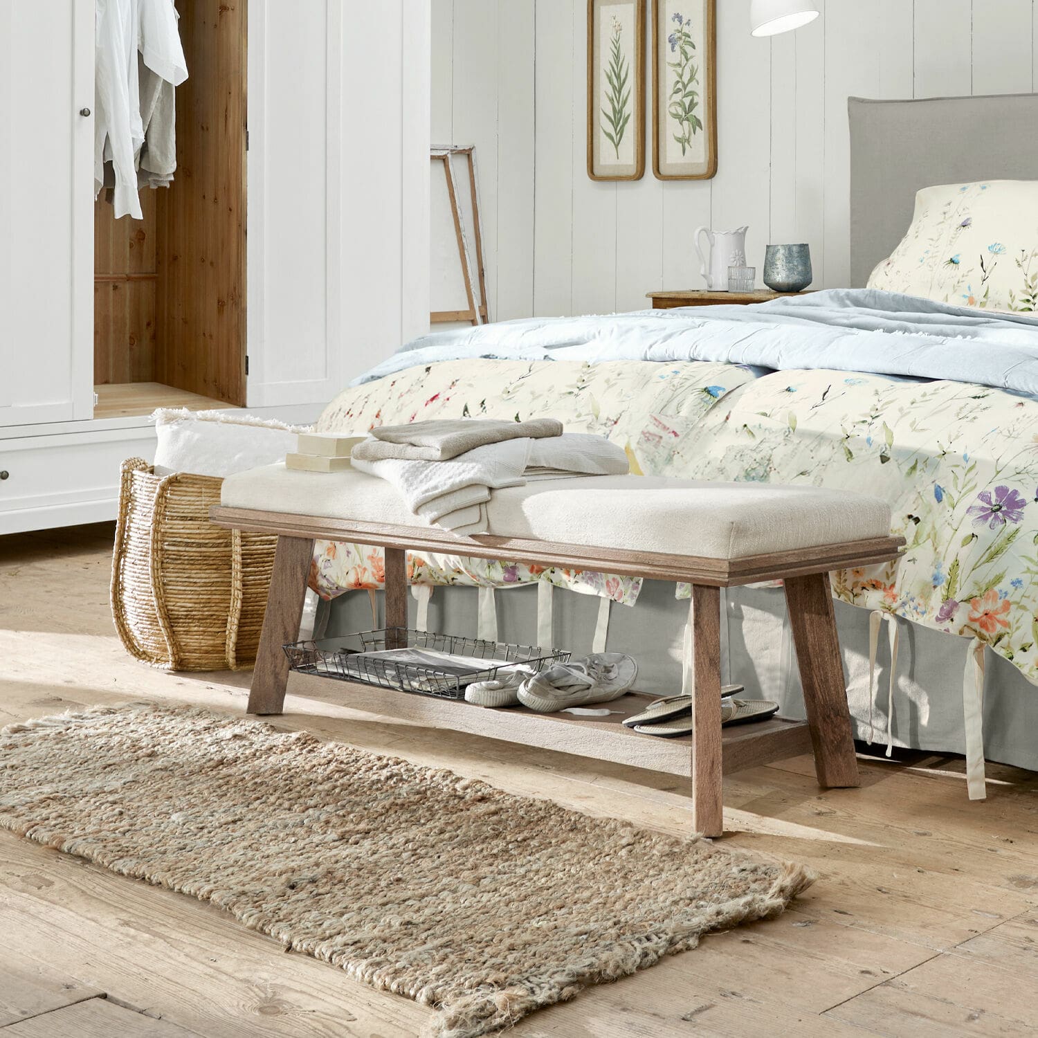 Bank Abington Holzbank mit hell gepolstertem Sitz im Schlafzimmer, natürlicher Teppich und florale Dekoration