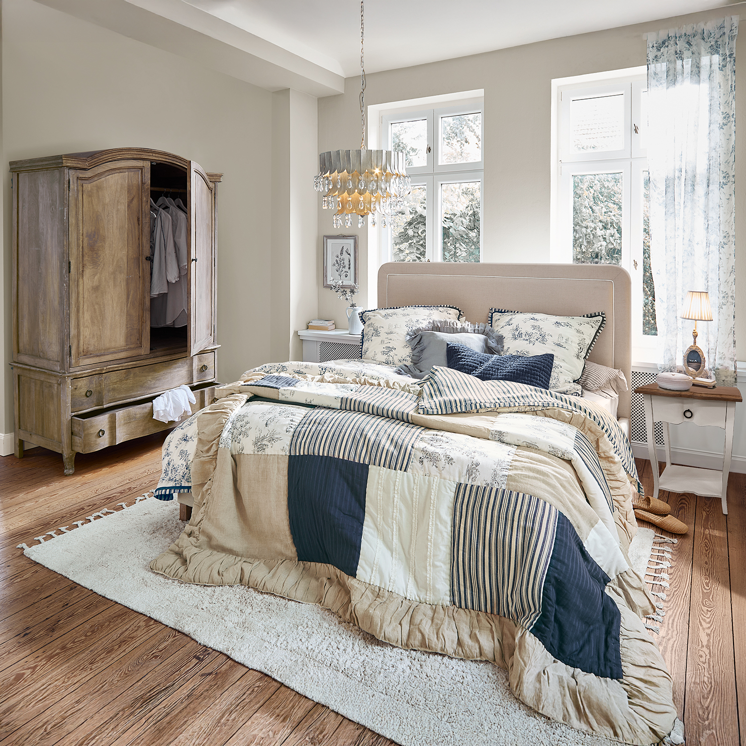 Gemütliches Schlafzimmer mit Patchwork-Bettdecke in Beige und Dunkelblau, Holzschrank und Teppich
