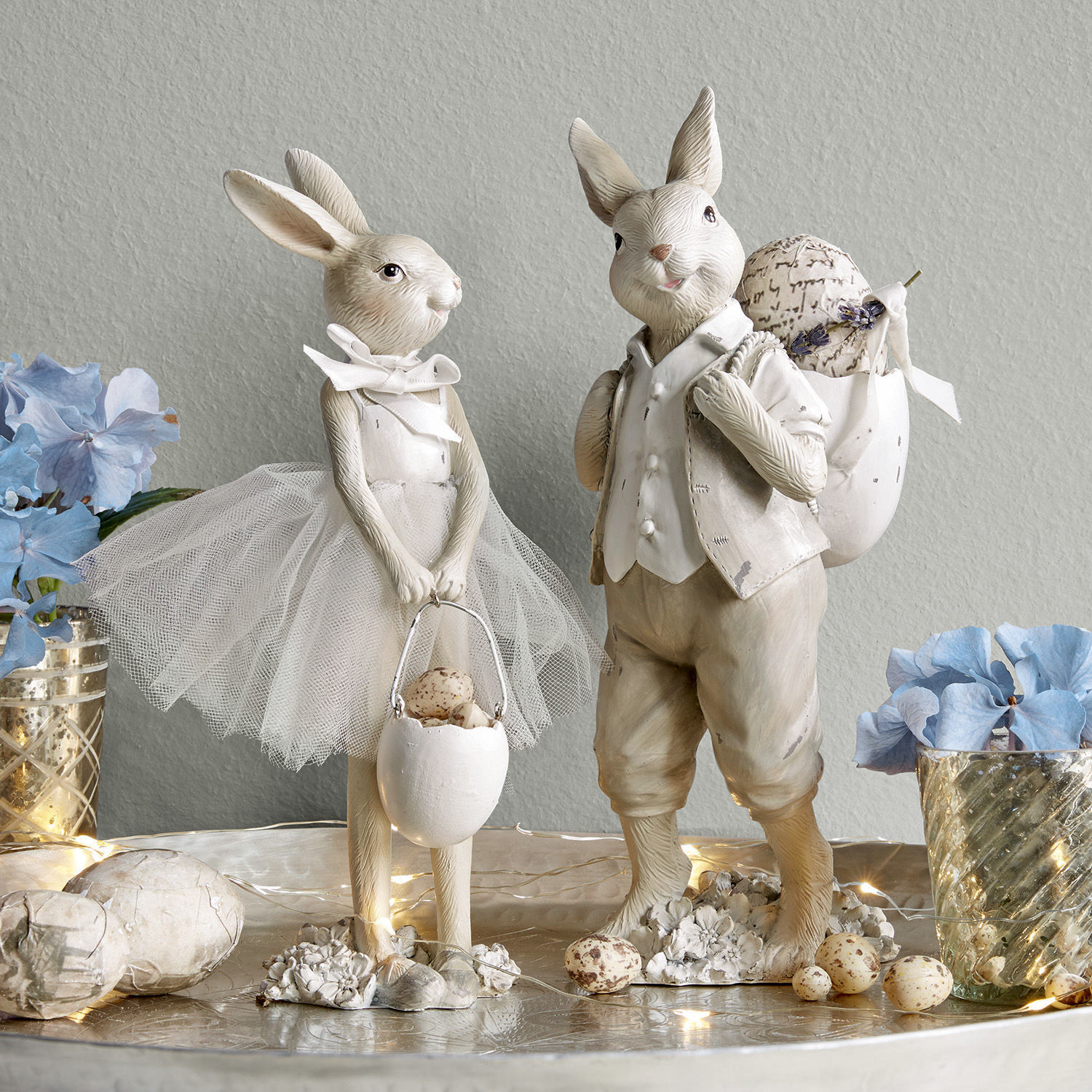 Hase 2er Set Perpignan Dekorative Hasenfiguren in hellen Farben mit Osteraccessoires und Blumen auf einem Tisch