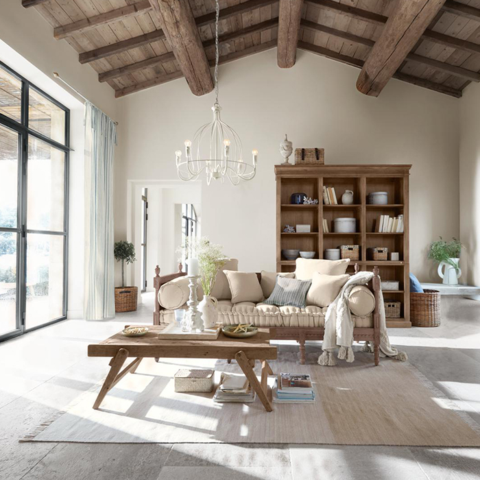 Gemütliches Wohnzimmer mit Holztisch und beigem Sofa, natürliche Materialien und helle Farben, rustikaler Stil