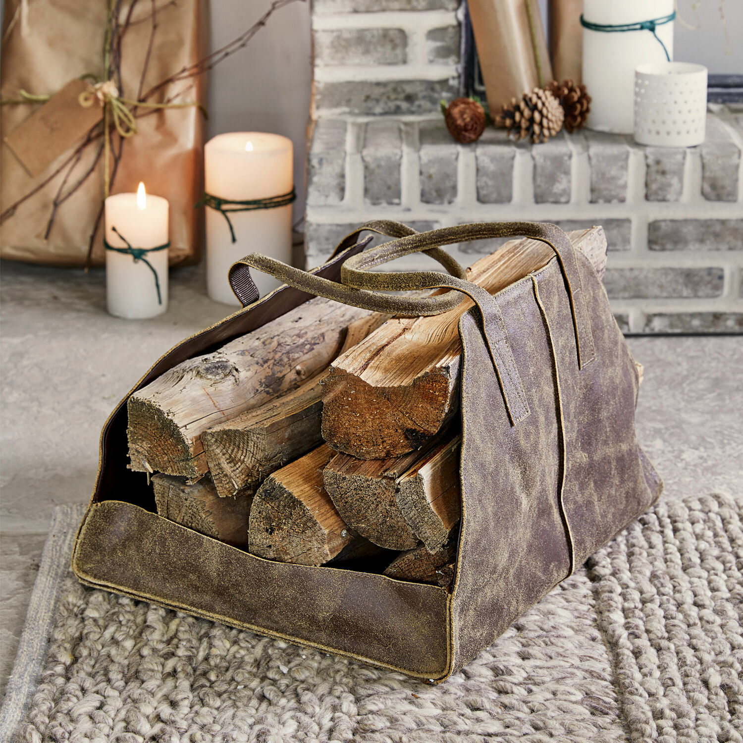 Tragetasche Bassila Braune Ledertasche für Kaminholz mit Griffen auf grauem Teppich vor dem Cheminée