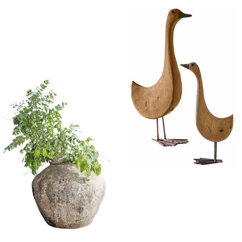 Dekorative Steinvase mit grünem Laub und hölzernen Vogeldekorationen