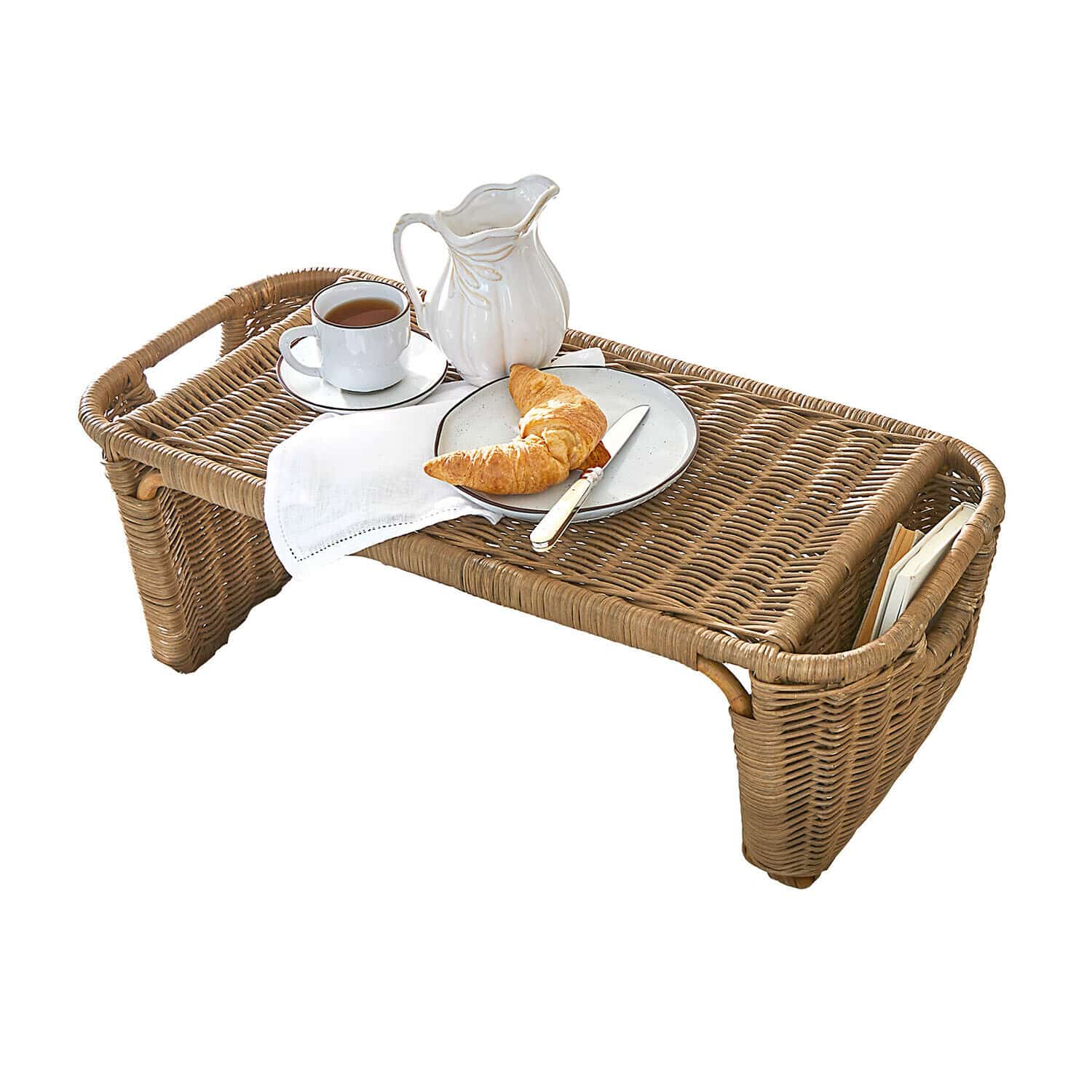 Brauner Rattantisch mit weissem Krug, Tasse und Gipfeli auf Teller für Frühstück