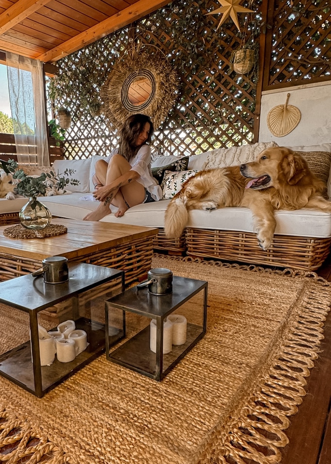 Gemütliches Wohnzimmer mit Rattansofa, Naturteppich und Dekorationen aus Seegras.