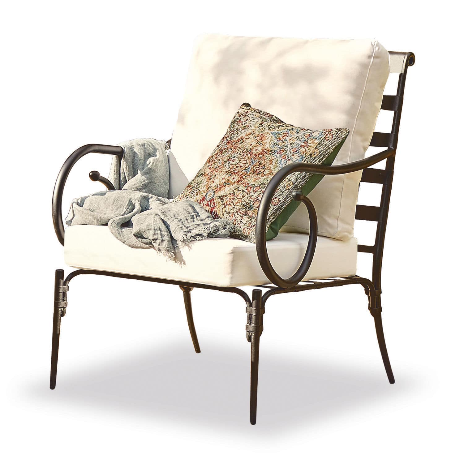 Sessel Neret Metallstuhl mit cremefarbenen Polstern und dekorativem Kissen mit buntem Muster