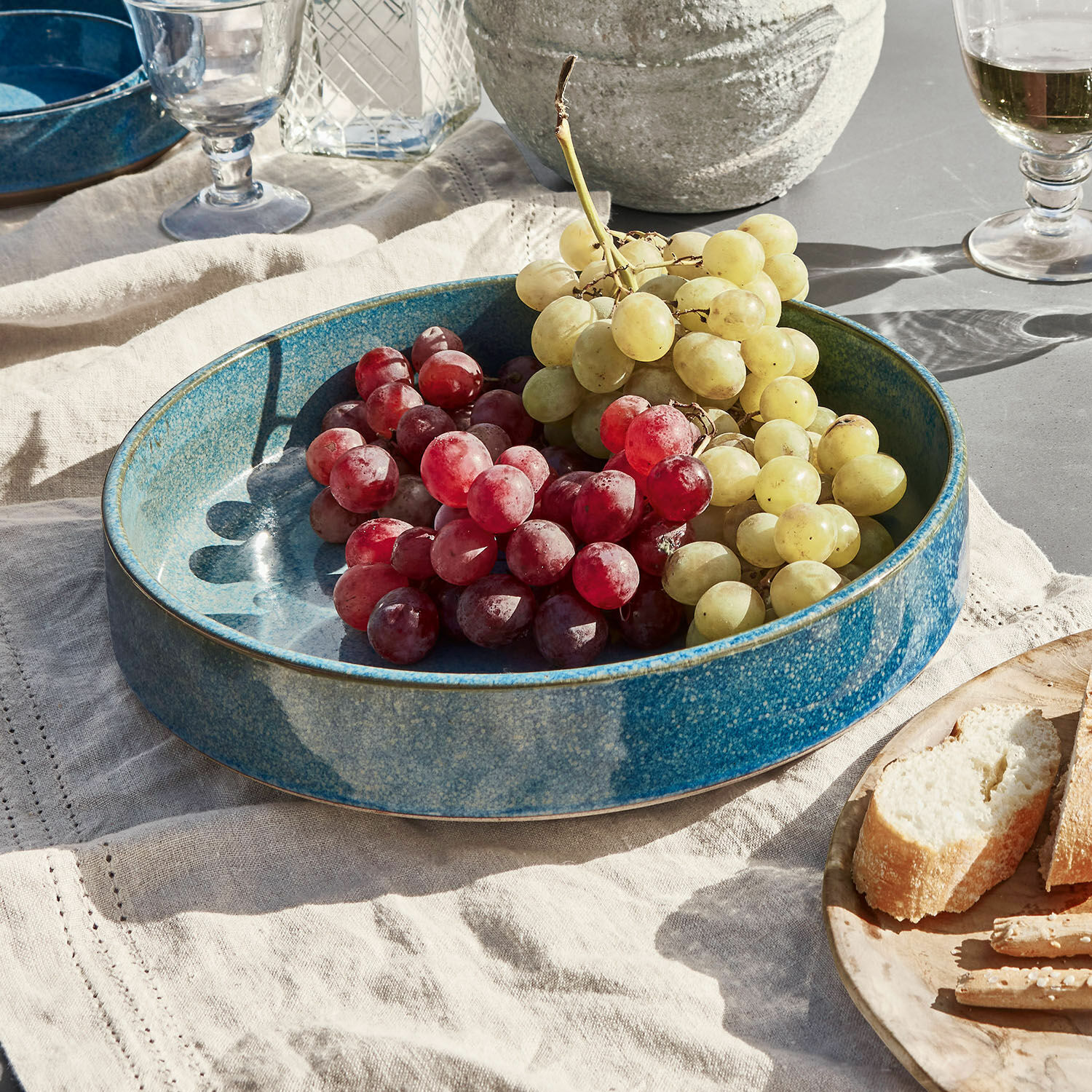 Salatschüssel Darney Blaue Keramikschale mit roten und grünen Trauben auf Leinentuch, Tischdekoration