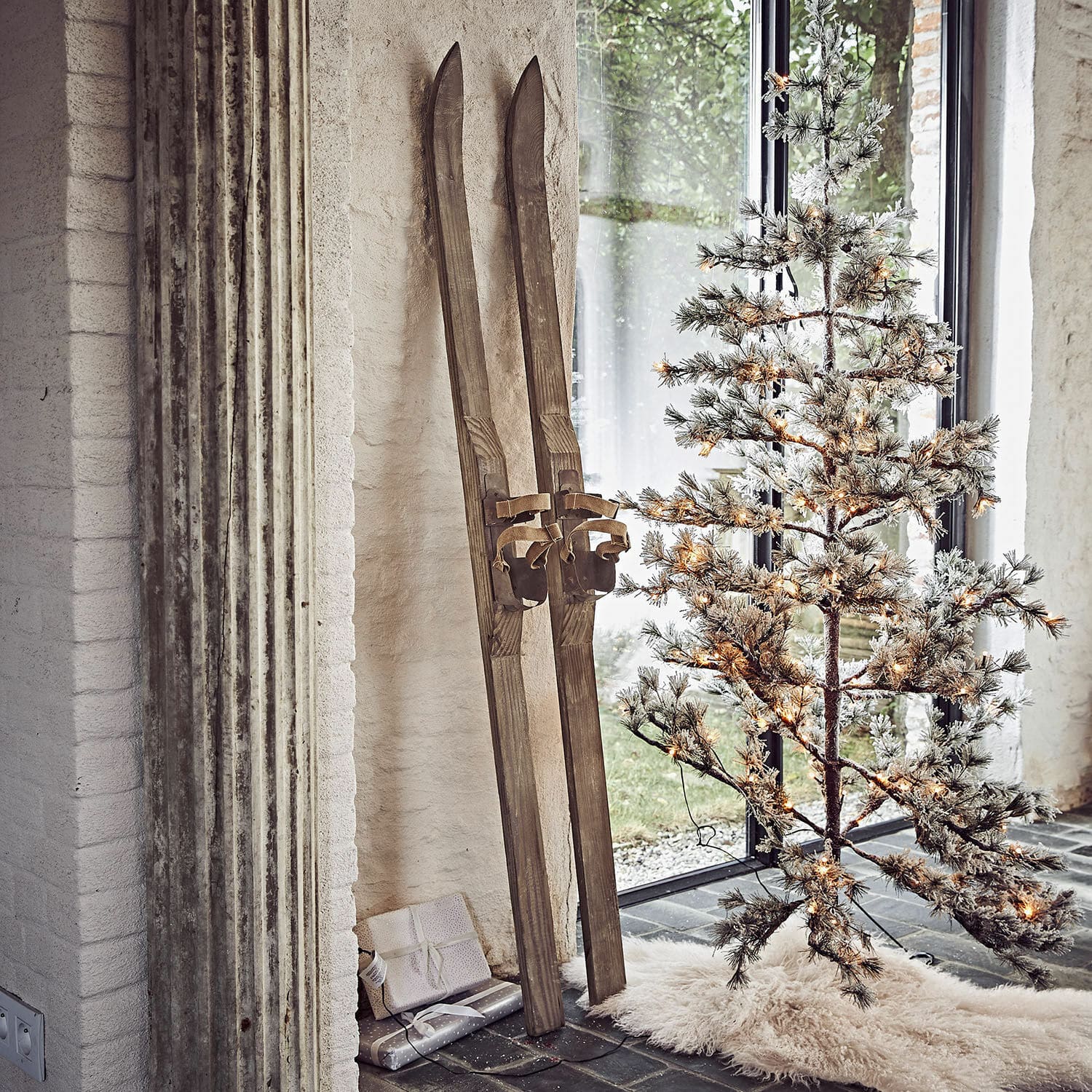Deko-Ski 2er Set Lambeth Vintage-Holzski neben beleuchtetem künstlichem Weihnachtsbaum auf weissem Teppichboden