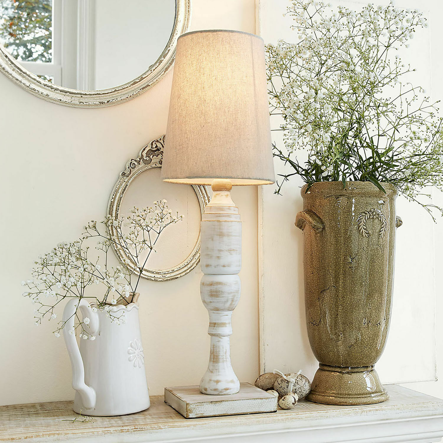 Tischlampe Yernisto Tischlampe aus weissem Holz mit beigem Lampenschirm vor Vintage-Dekoration mit Vase und Spiegel