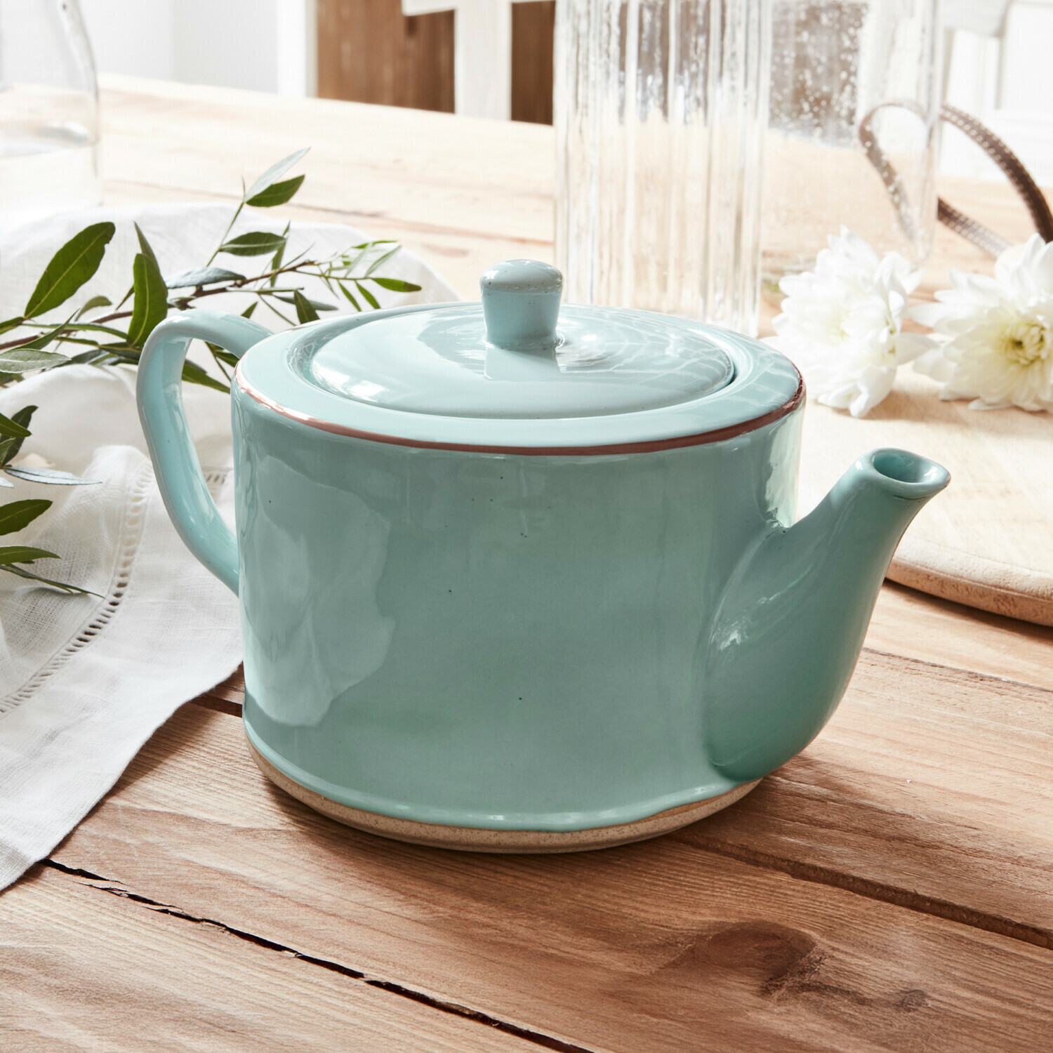 Teekanne Biarré Grüne Keramik-Teekanne mit Deckel auf Holztisch mit weissen Blumen und grünen Blättern