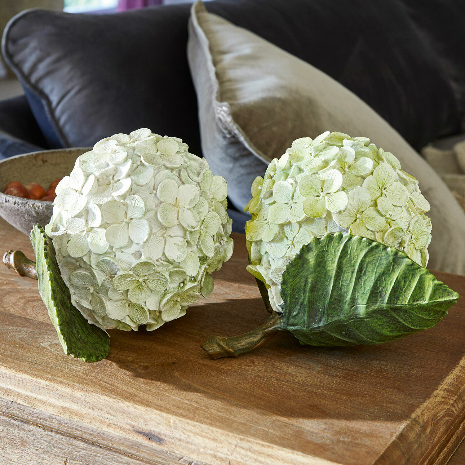 Dekoblume 2er Set Hortensie Dekorative Blumenbälle aus cremegrünem Material auf einem Holztisch