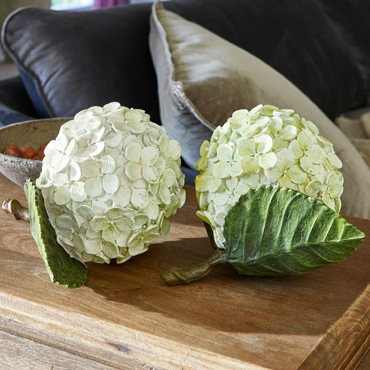Dekoblume 2er Set Hortensie Dekorative Blumenbälle aus cremegrünem Material auf einem Holztisch