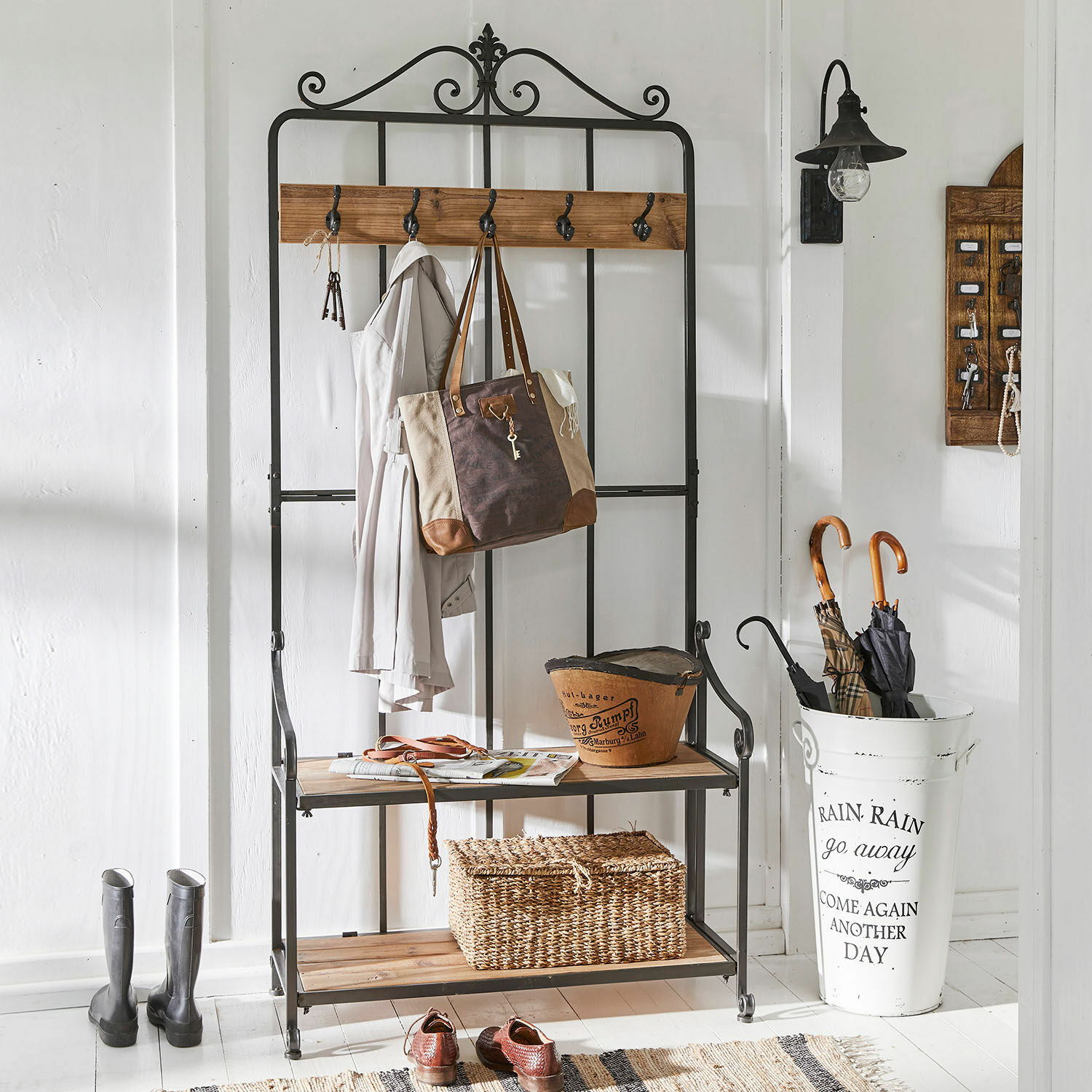 Garderobe Sussy Schwarze Metallgarderobe mit Holzablagen und Haken für Jacken und Taschen im Gang