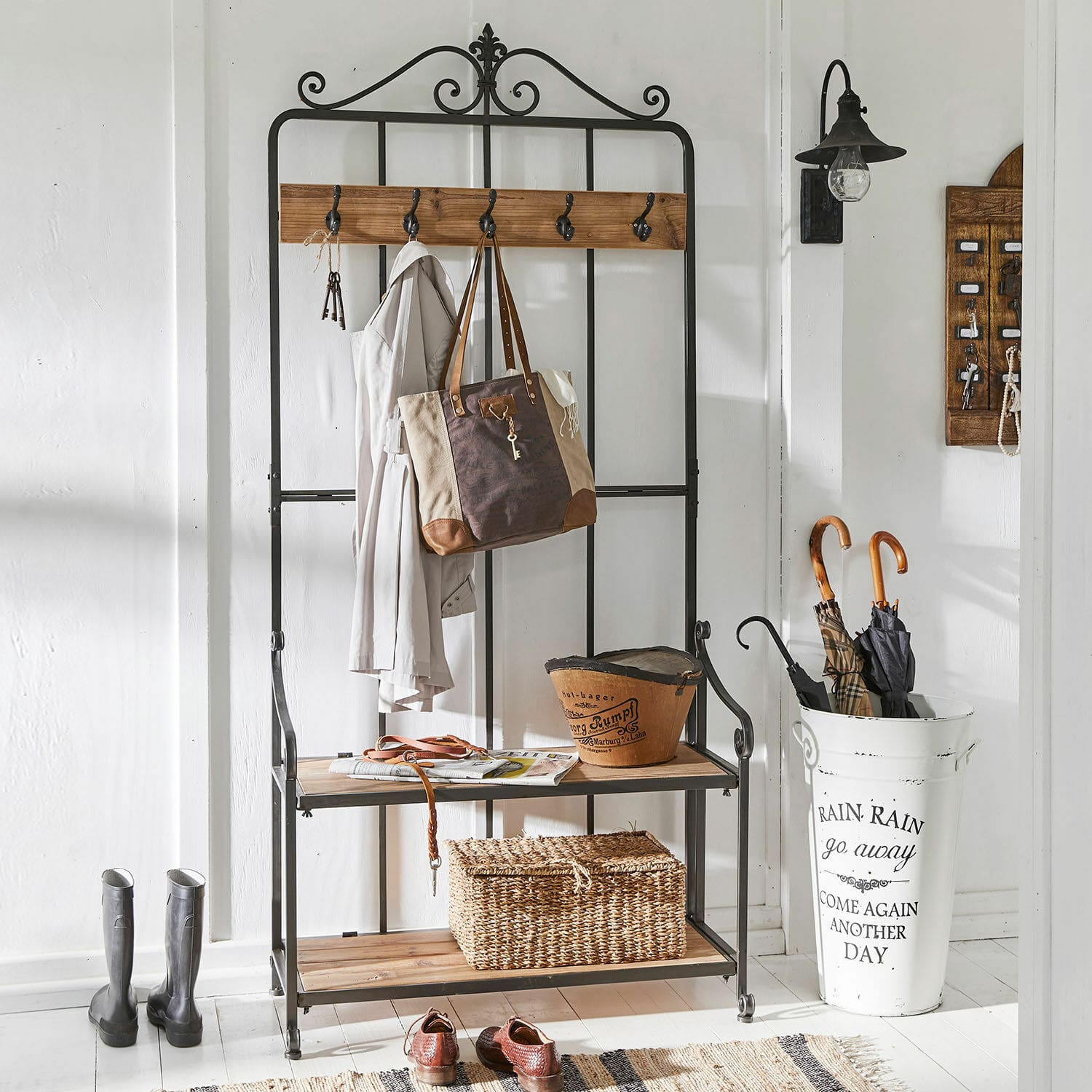 Garderobe Sussy Schwarze Metallgarderobe mit Holzablagen und Haken für Jacken und Taschen im Gang