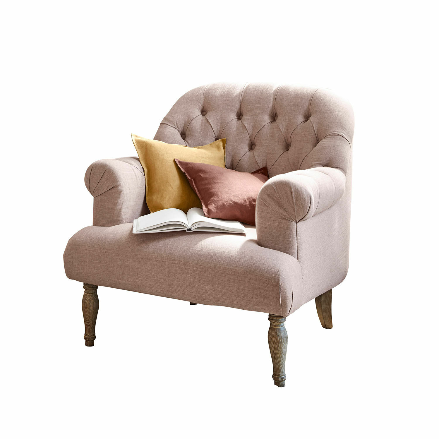 Sessel Shambrook Rosa gepolsterte Couch mit Holzbeinen, dekoriert mit zwei Kissen und einem offenen Buch.