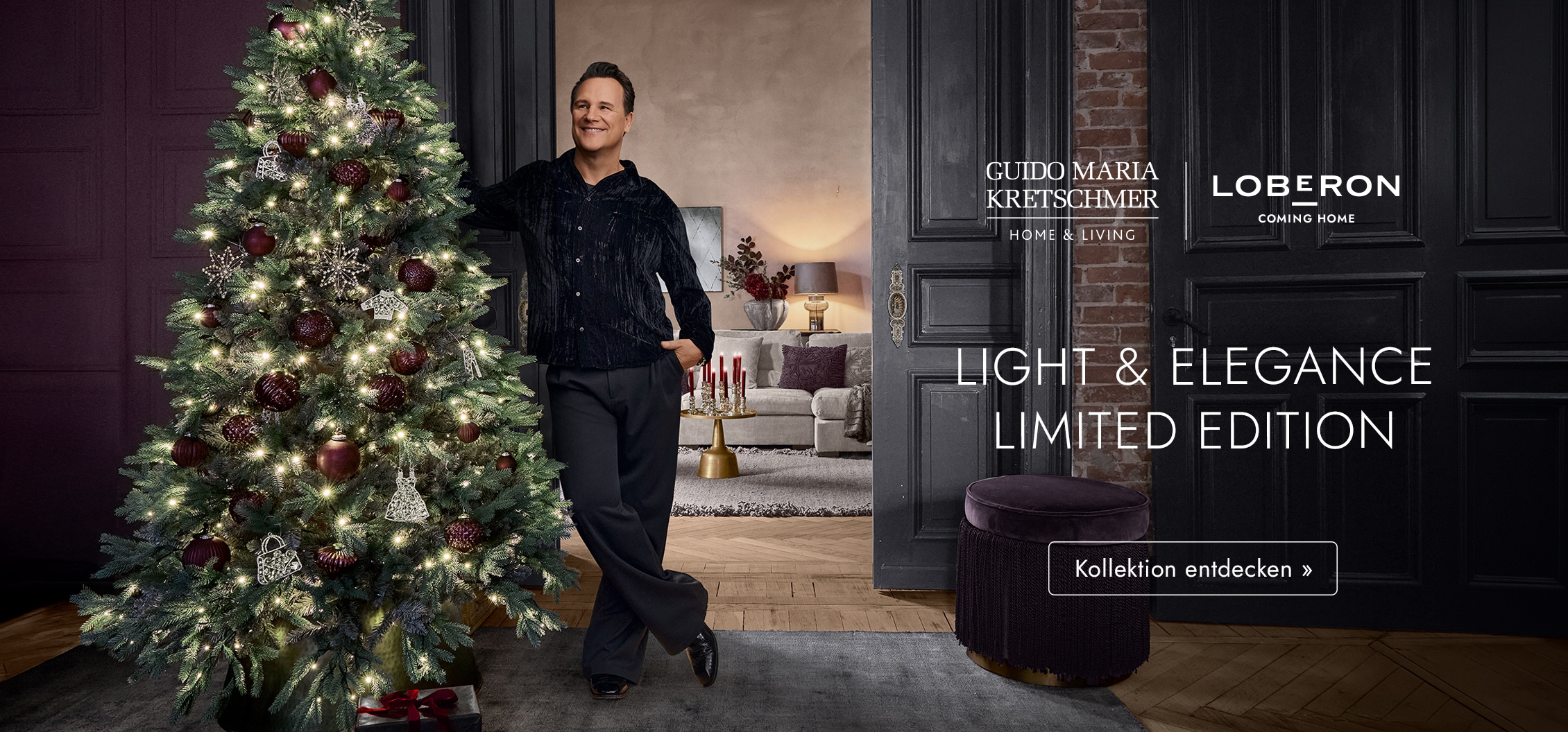 Mann neben beleuchtetem Weihnachtsbaum mit bordeauxroten und silbernen Dekorationen in elegantem Raum