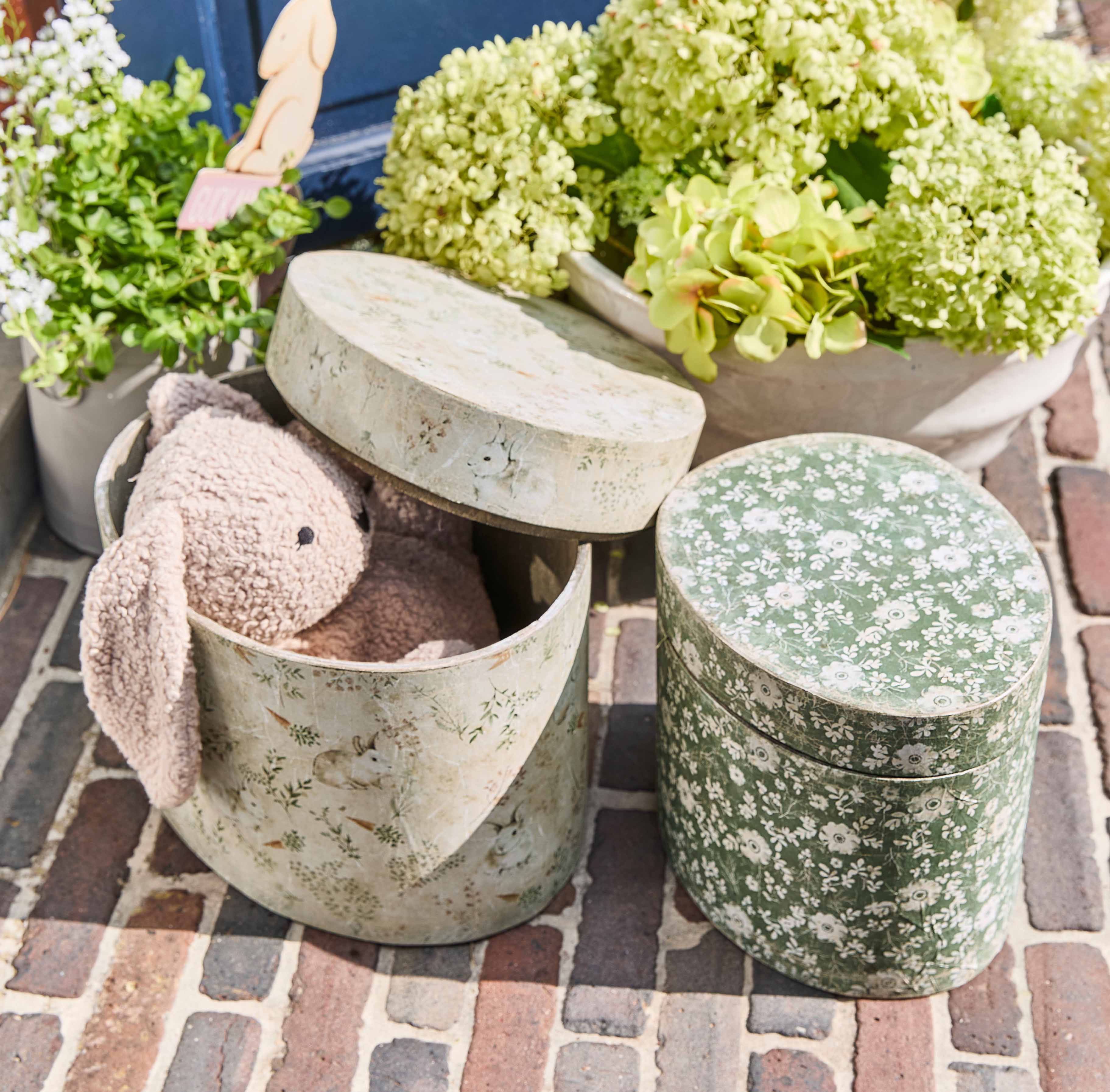 Ovale Dekorationsdosen mit Blumen- und Hasenmotiven, eine mit rosa Plüschhase innen