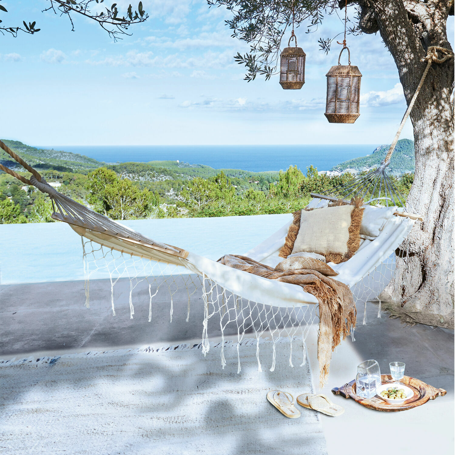 Hängematte Moline Weisse Baumwollhängematte mit Kissen und Decke auf Terrasse mit Meer- und Waldblick