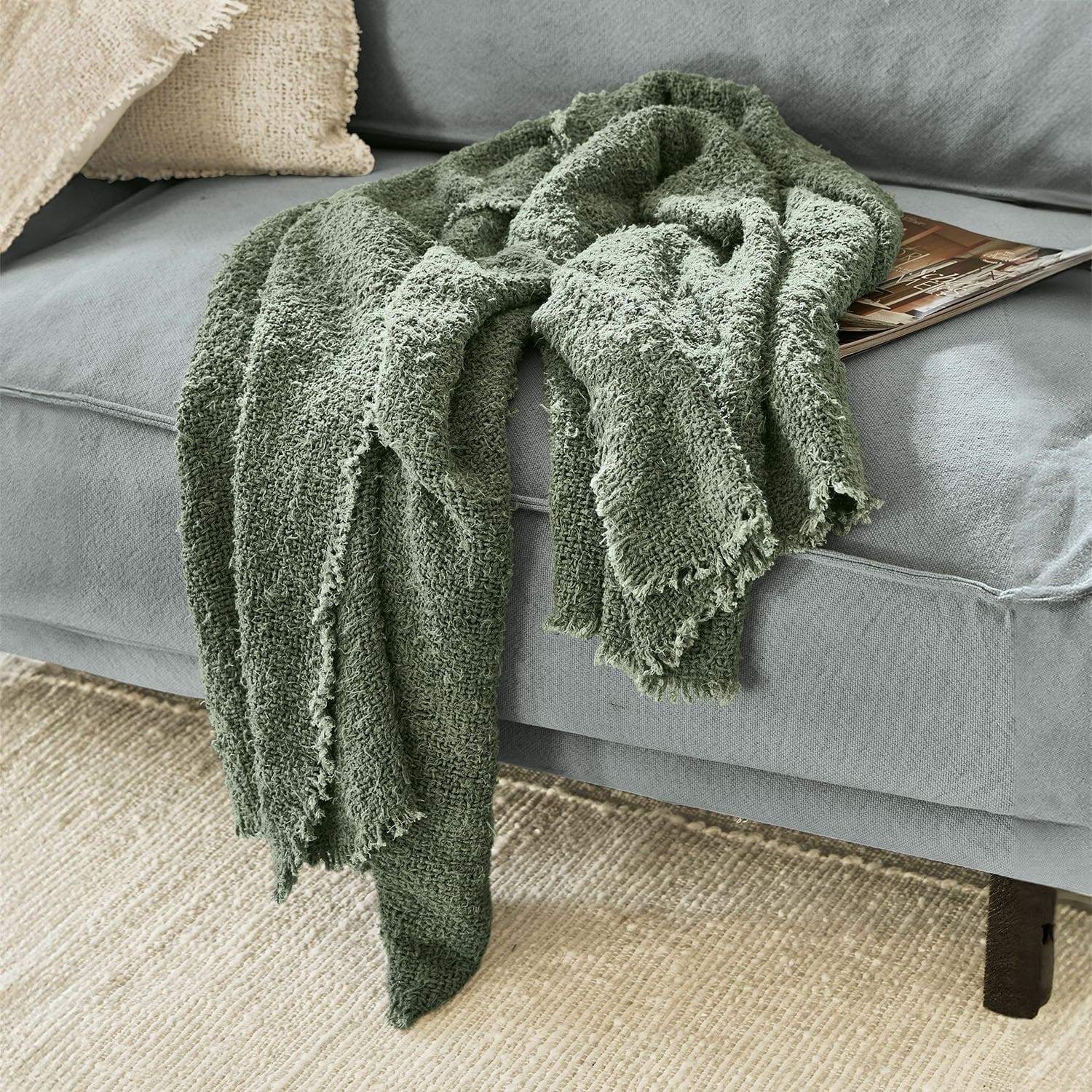 Plaid Juliana Weiche grüne Baumwolldecke auf grauem Sofa, dekoratives und gemütliches Wohnaccessoire
