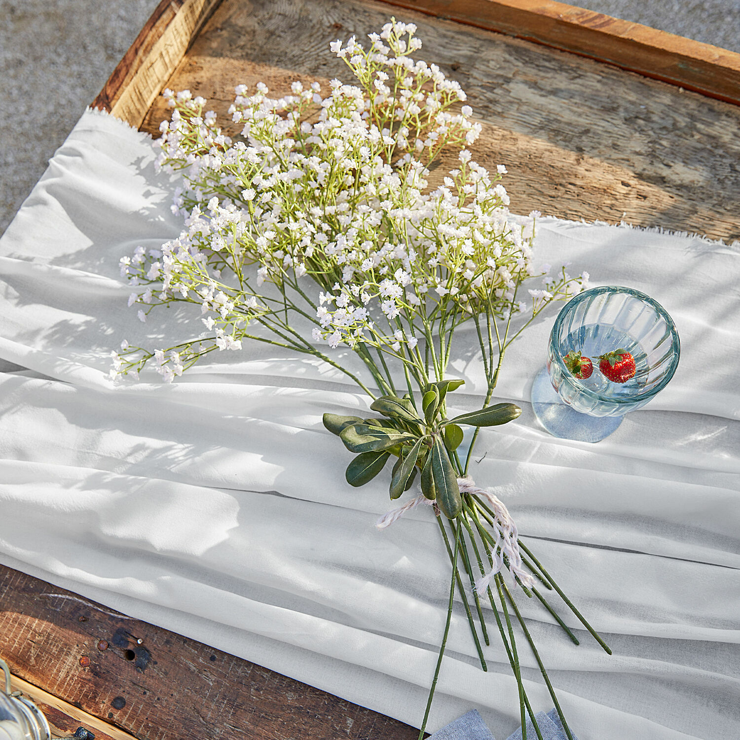 Deko-Blumenstrauss Lorraine Strauß weisser Blumen auf weissem Stoff auf Holztisch, natürliche Wohnraumdekoration
