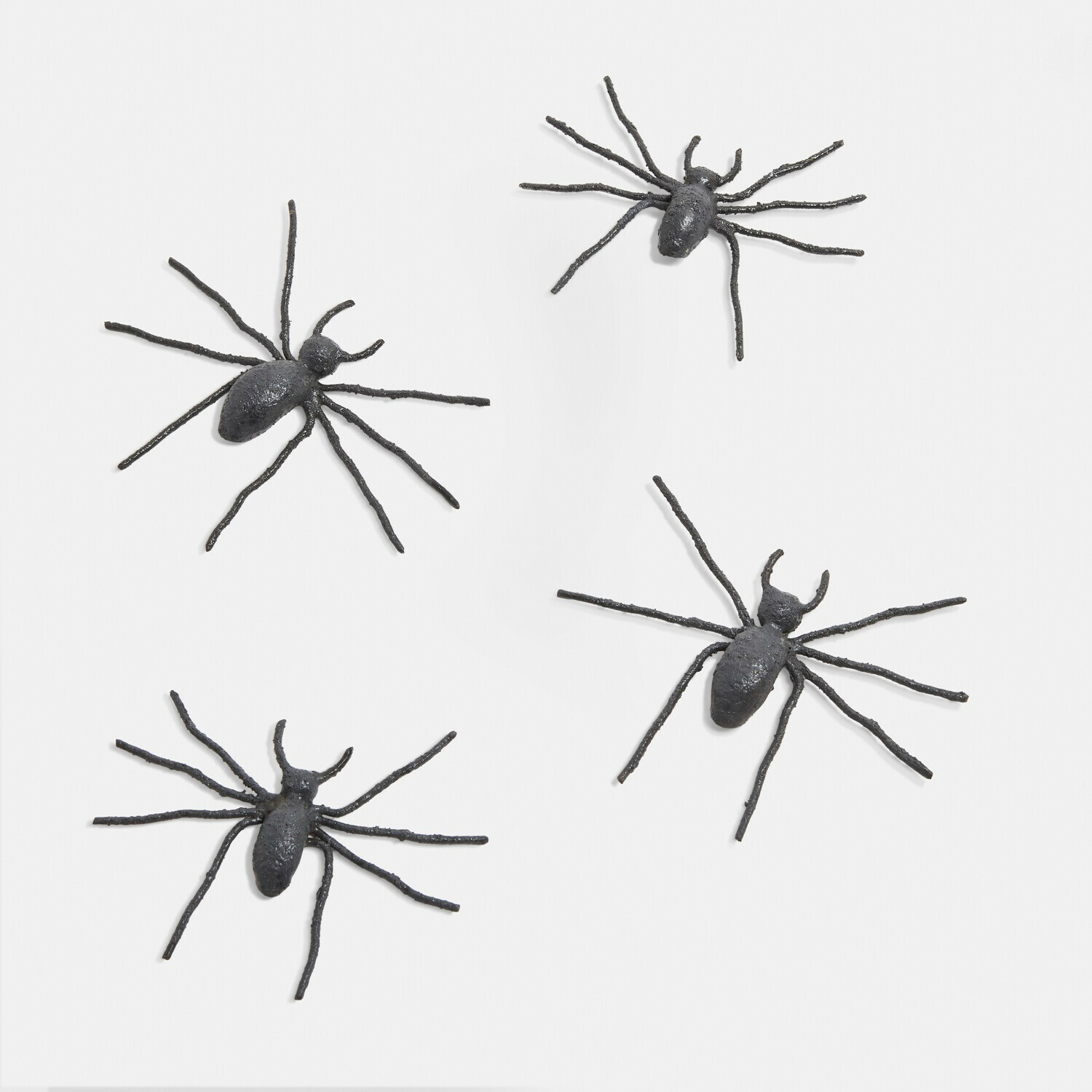 Vier schwarze dekorative Metallspinnen auf weissem Hintergrund, ideal für Halloween und Wanddekoration