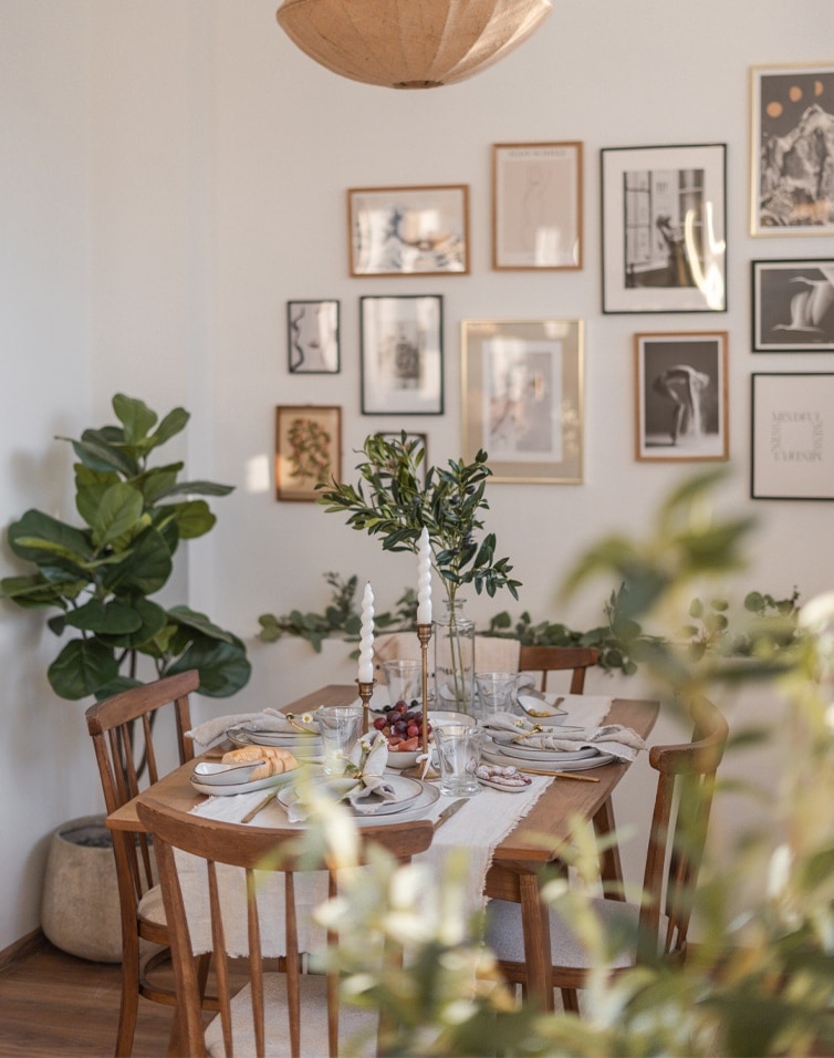 Esszimmer mit Holztisch und Stühlen, grünen Dekorationen und Kerzen, natürlicher Einrichtungsstil