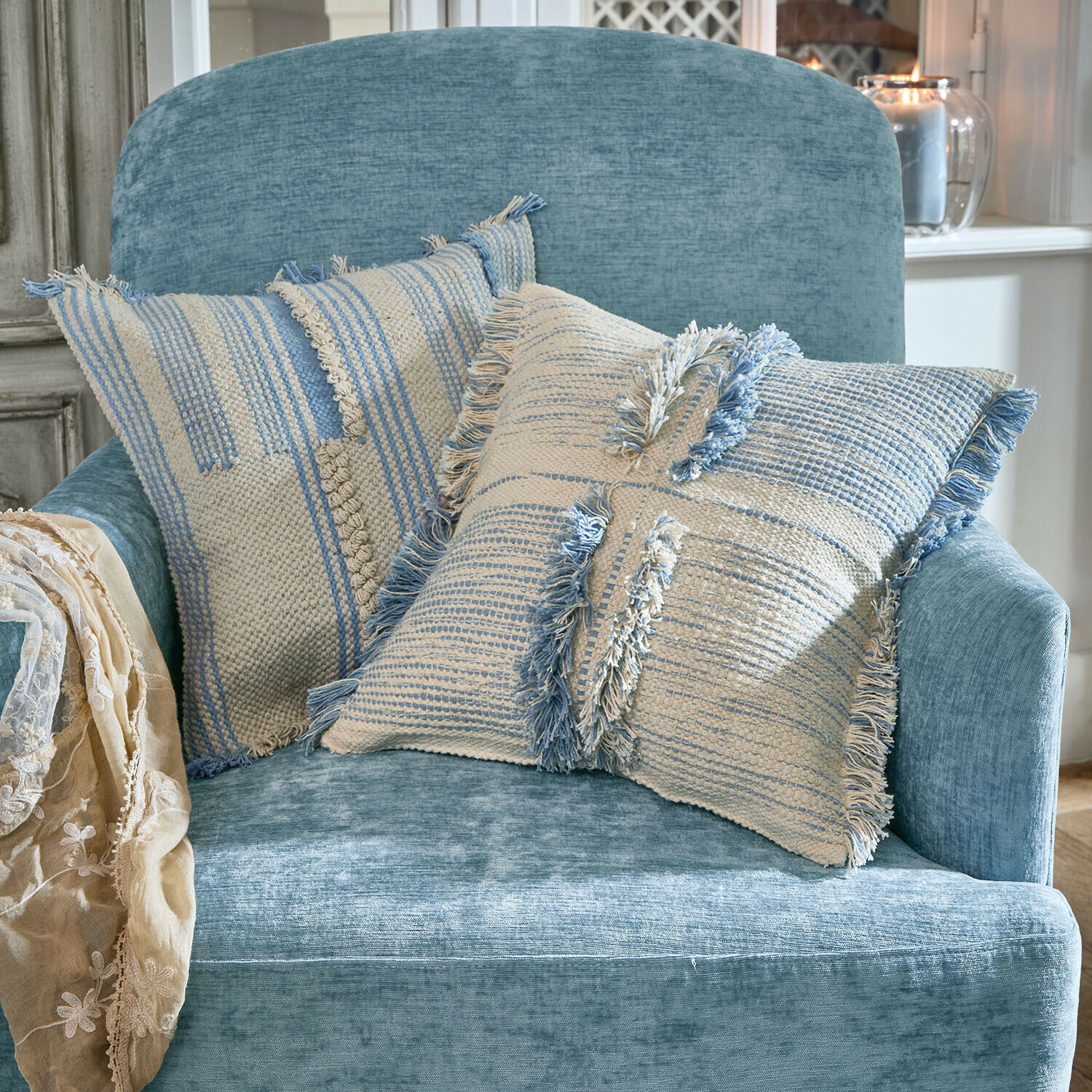 Kissenhülle 2er Set Ciel d'Azur Zwei dekorative Baumwollkissen in Creme und Blau auf einem weichen blauen Sessel im Wohnzimmer