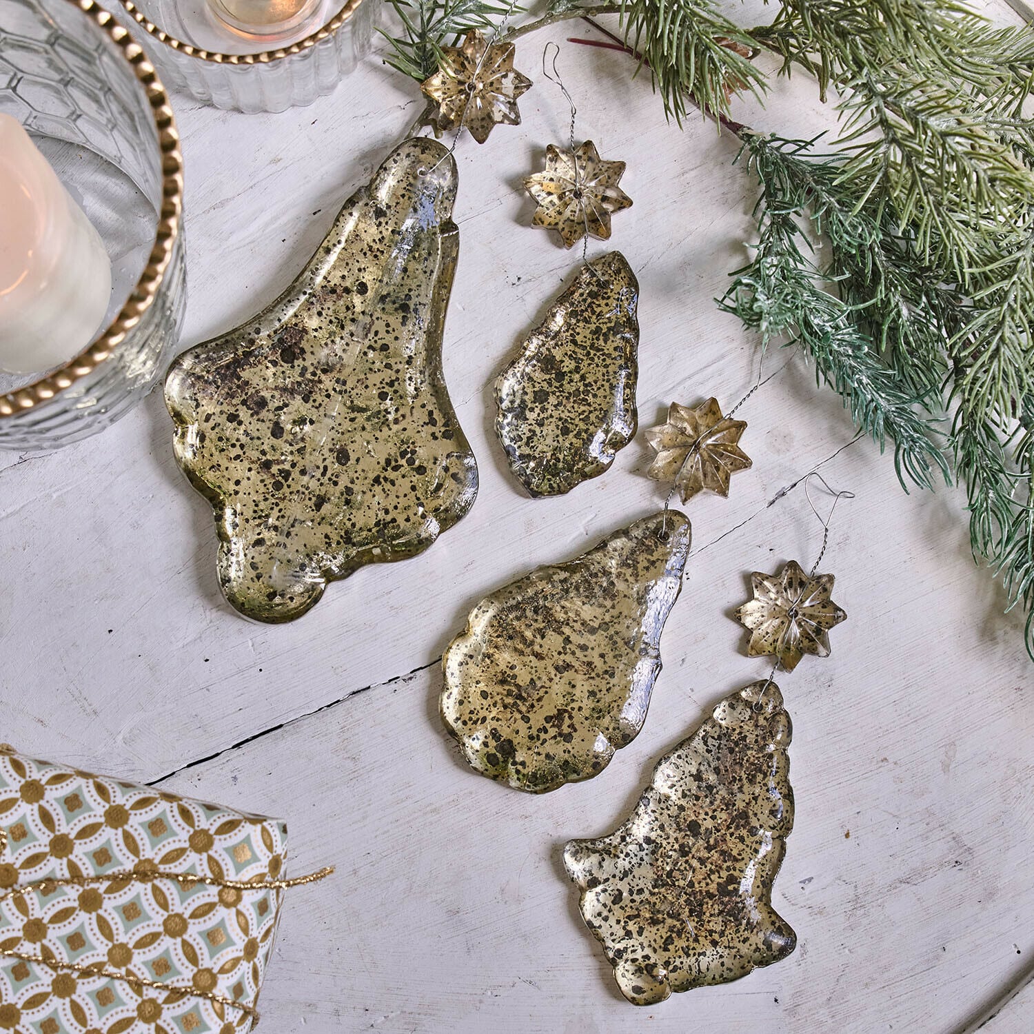 Weichnachtsschmuck 4er Set Dolenza Set goldfarbiger Metall-Weihnachtsanhänger in Glocken- und Sternform auf weissem Hintergrund