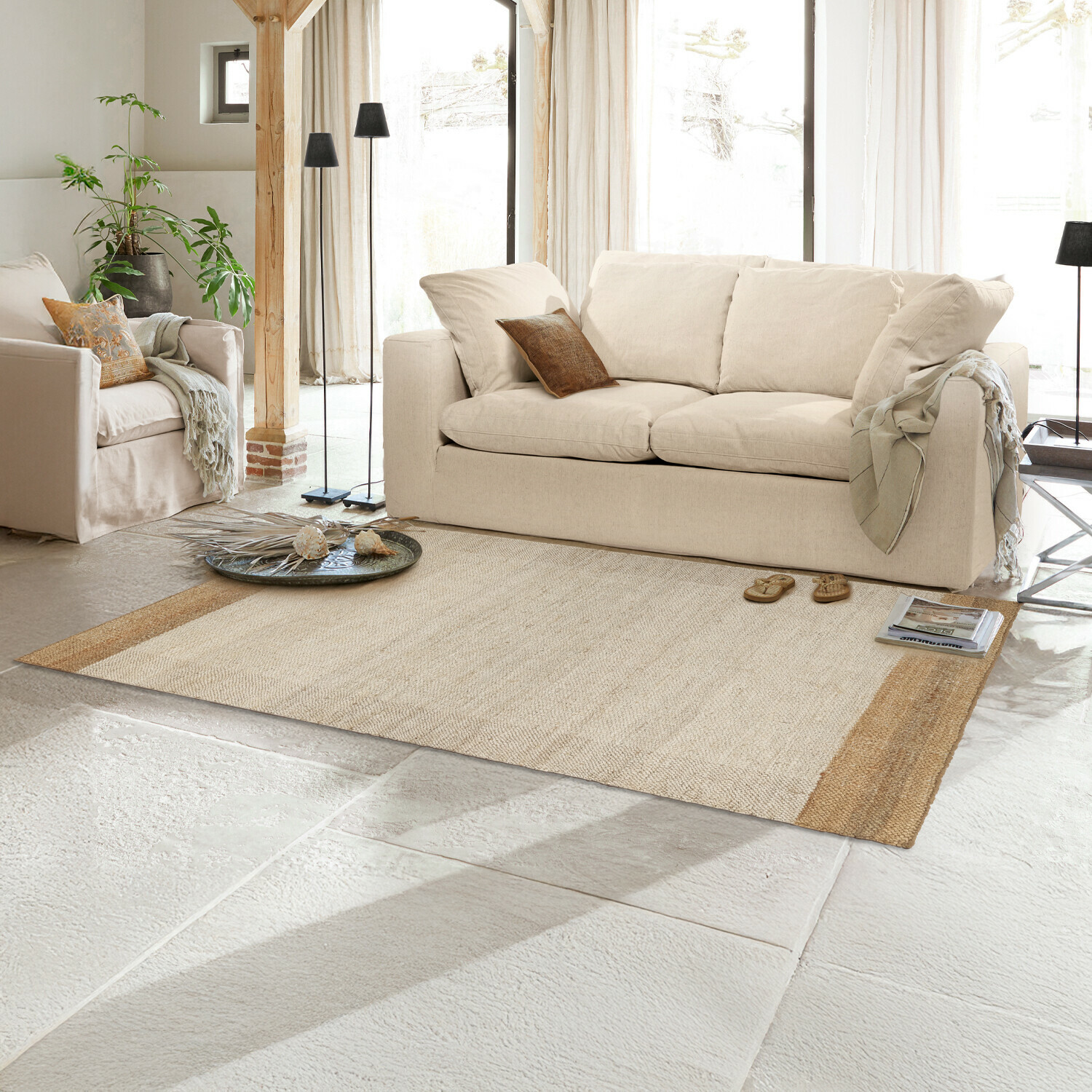 Beiger Naturfaser-Teppich im hellen Wohnzimmer mit cremefarbener Couch und Dekorationen