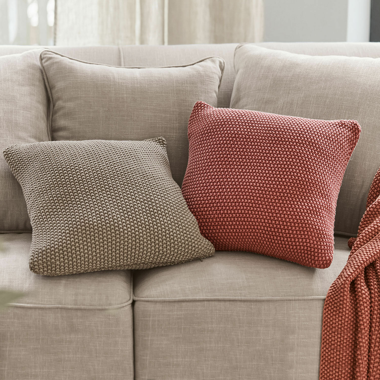 Kissenhülle 2er Set Terry Zwei gestrickte Dekokissen in Beige und Ziegelrot auf einem hellgrauen Sofa für gemütliches Wohnen