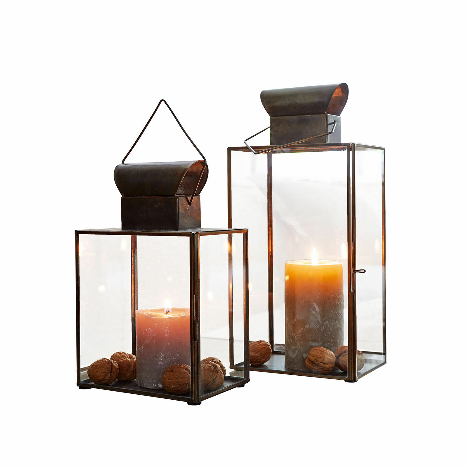 Laterne 2er Set Pluton Zwei Metalllaternen mit klarem Glas und braunen Kerzen, dekoriert mit Wallnüssen.