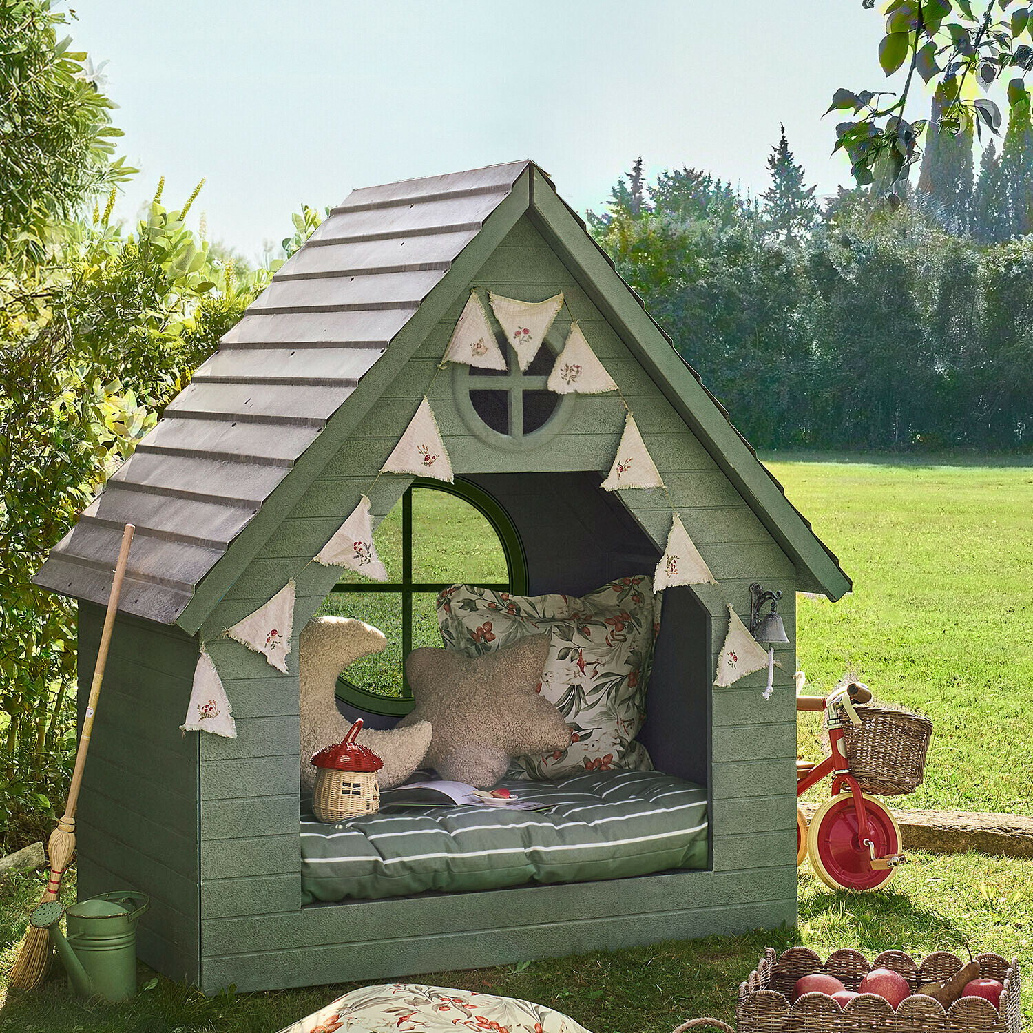 Grünes Holz-Gartenhaus mit Kissen und dekorativen Wimpeln, gemütliche Entspannungsecke im Garten
