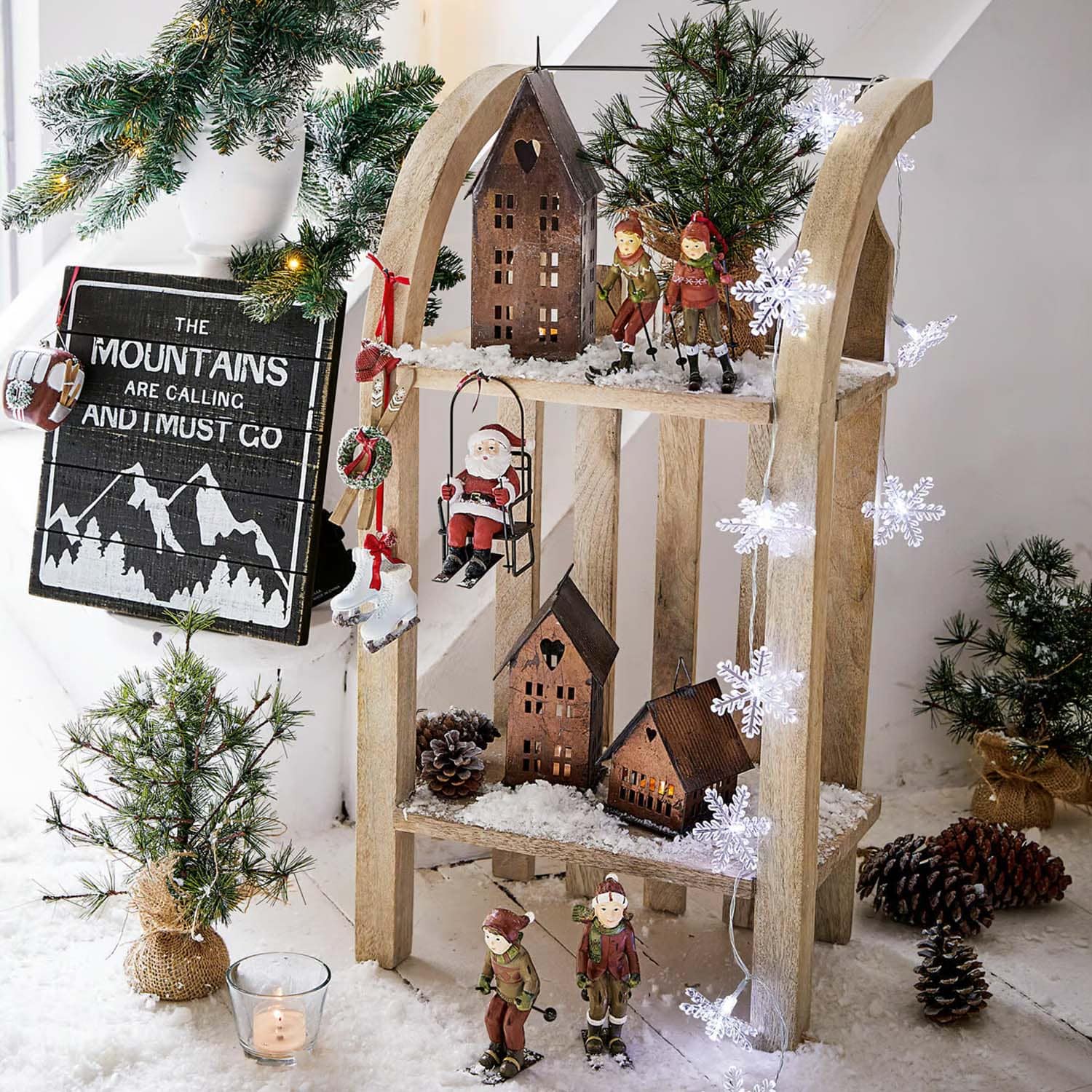 Weihnachtliche Holzdekoration mit Skifahrerfiguren, Samichlaus und Häusern auf Kunstschnee