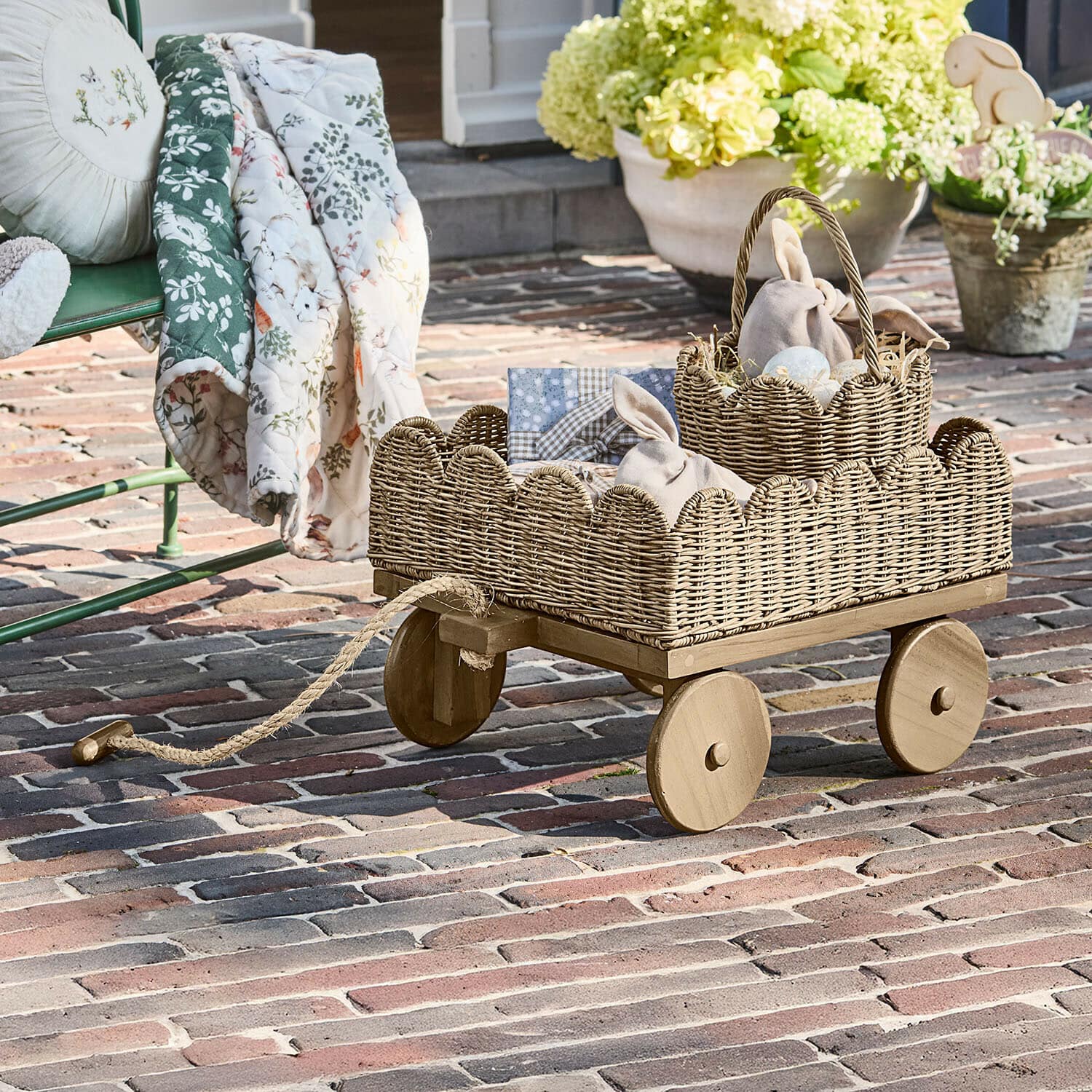 Kinderbollerwagen Whimsywood Holzwagen mit naturfarbenem Weidenkorb auf Terrasse mit Osterdekorationen