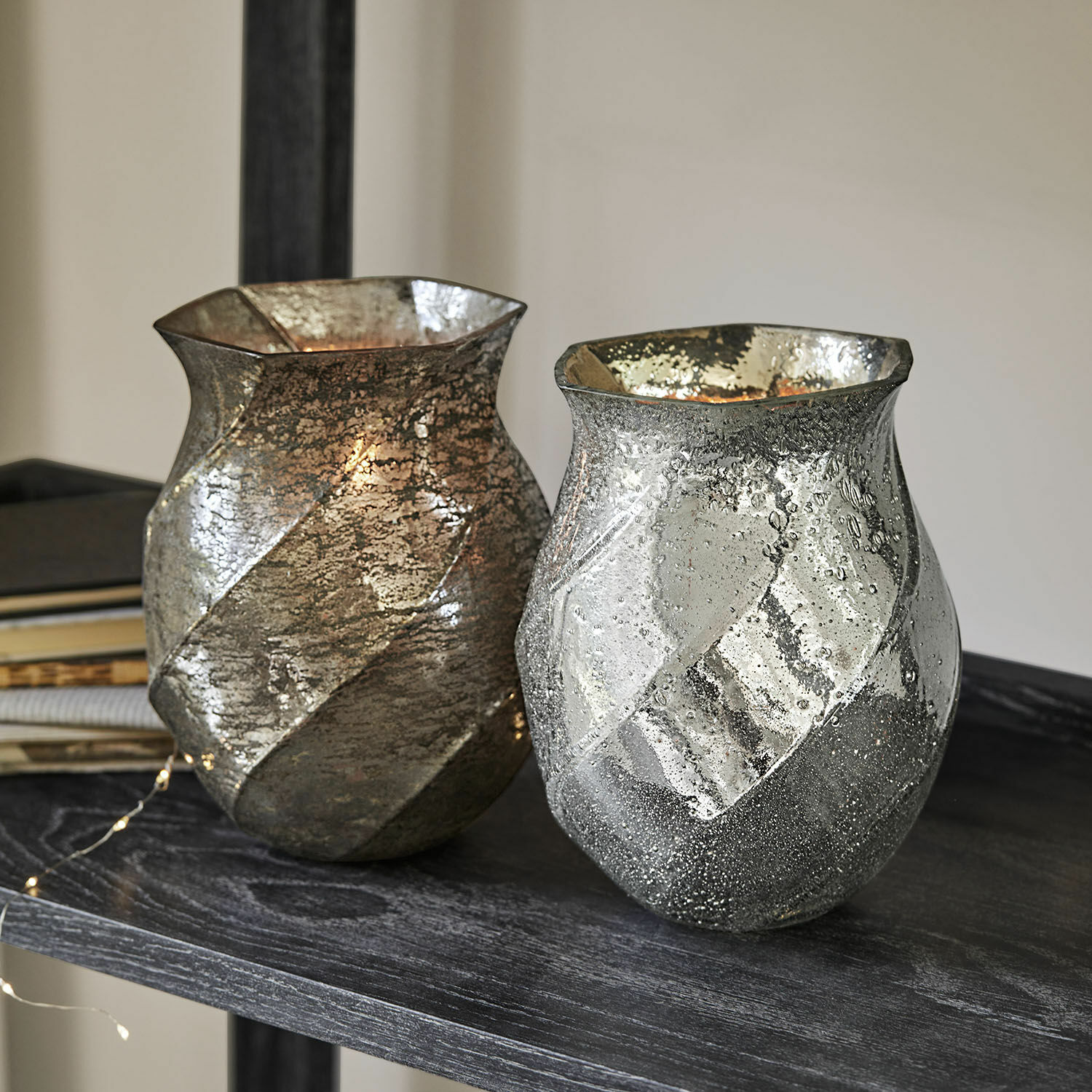Windlicht 2er Set Tixovel Zwei dekorative Glasvasen in Silber und Gold mit Struktur auf dunklem Regal