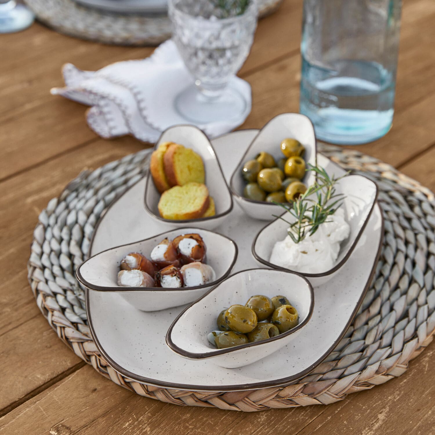 Servierschälchen 6er Set Biarré Weisse Keramikschälchen mit Oliven und Frischkäse auf geflochtenem Untersetzer auf Holztisch