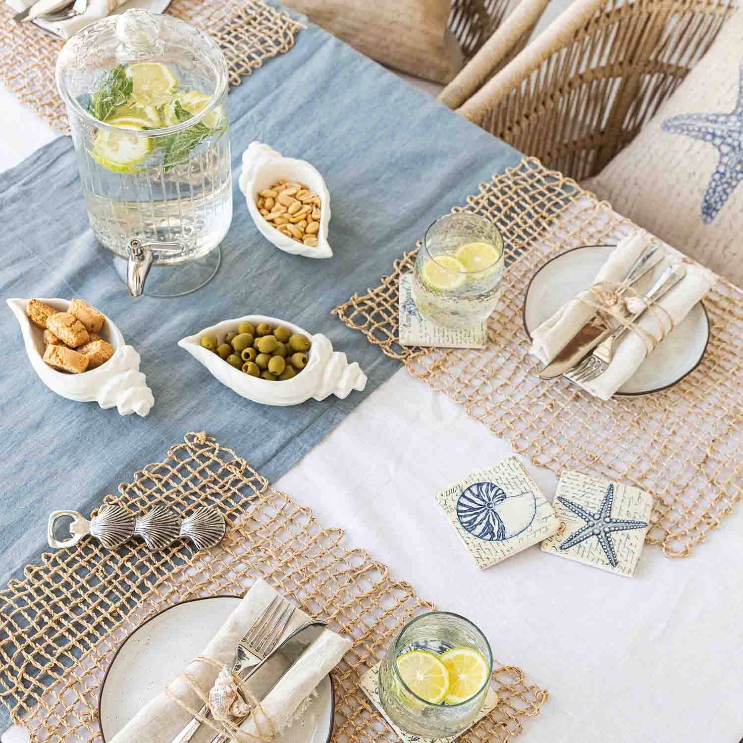 Sommerlicher Tisch mit maritimer Dekoration, weisse Muschel-Schalen aus Keramik mit Snacks und Limonade