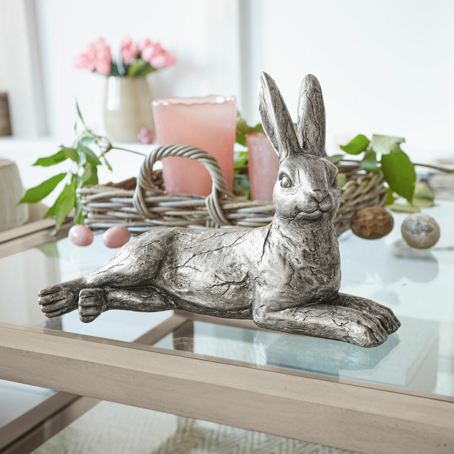 Hase Fiorentin Dekorativer silberner Metallhase auf Glastisch mit frühlingshafter Dekoration