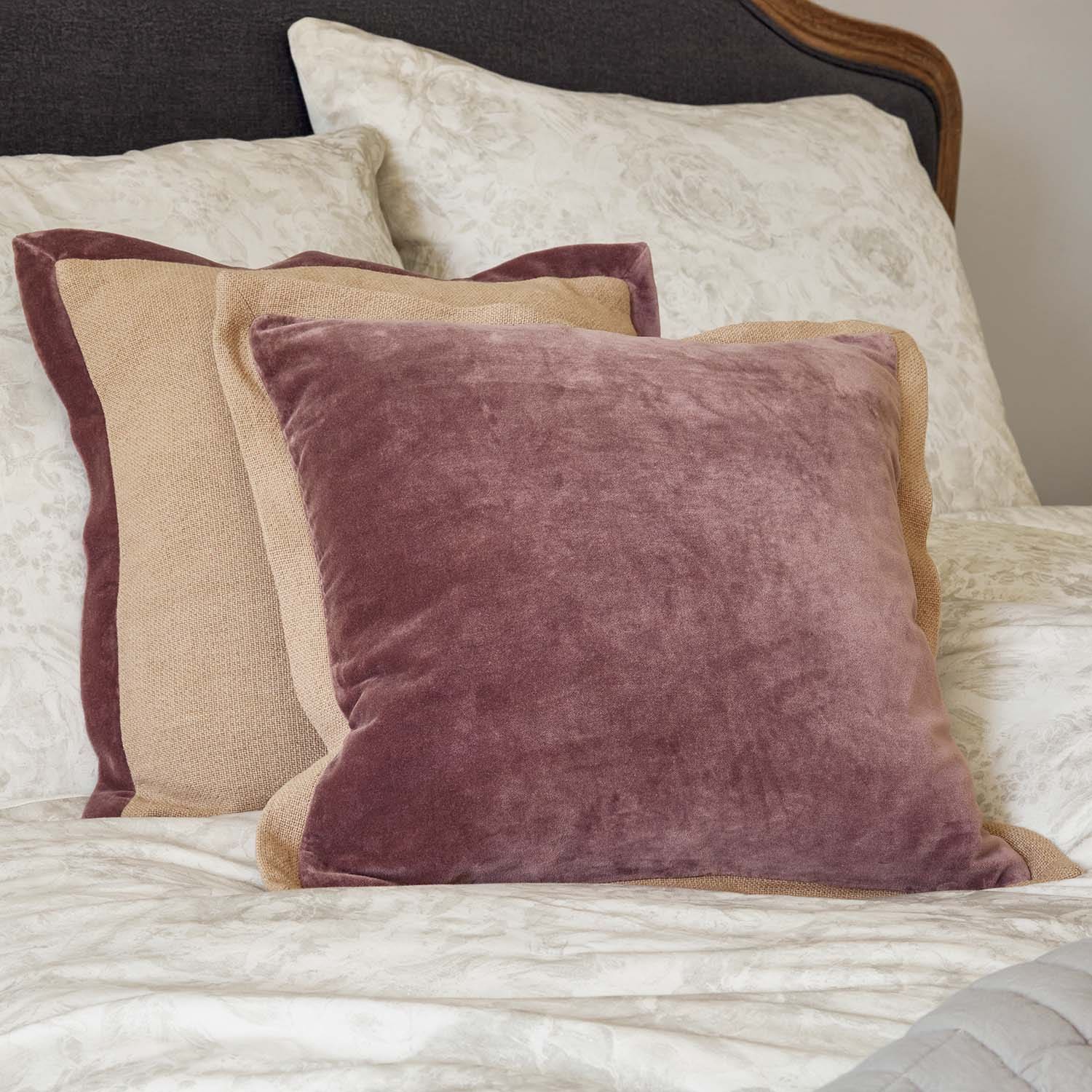 Dekoratives Kissen-Set aus Samt und Leinen in Rosa und Beige auf gemustertem Bett